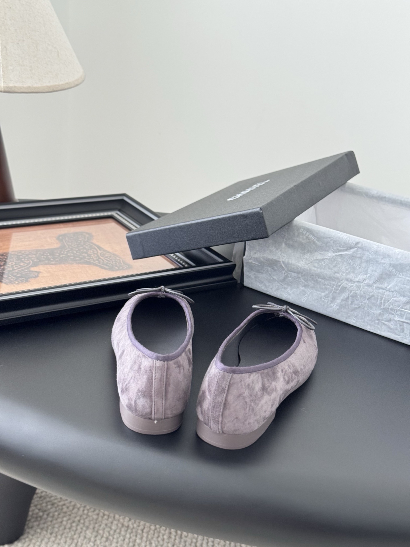 A pair of mauve suede Chanel ballerina flats featuring a bow and CC logo, displayed with a Chanel box. - Hình 6