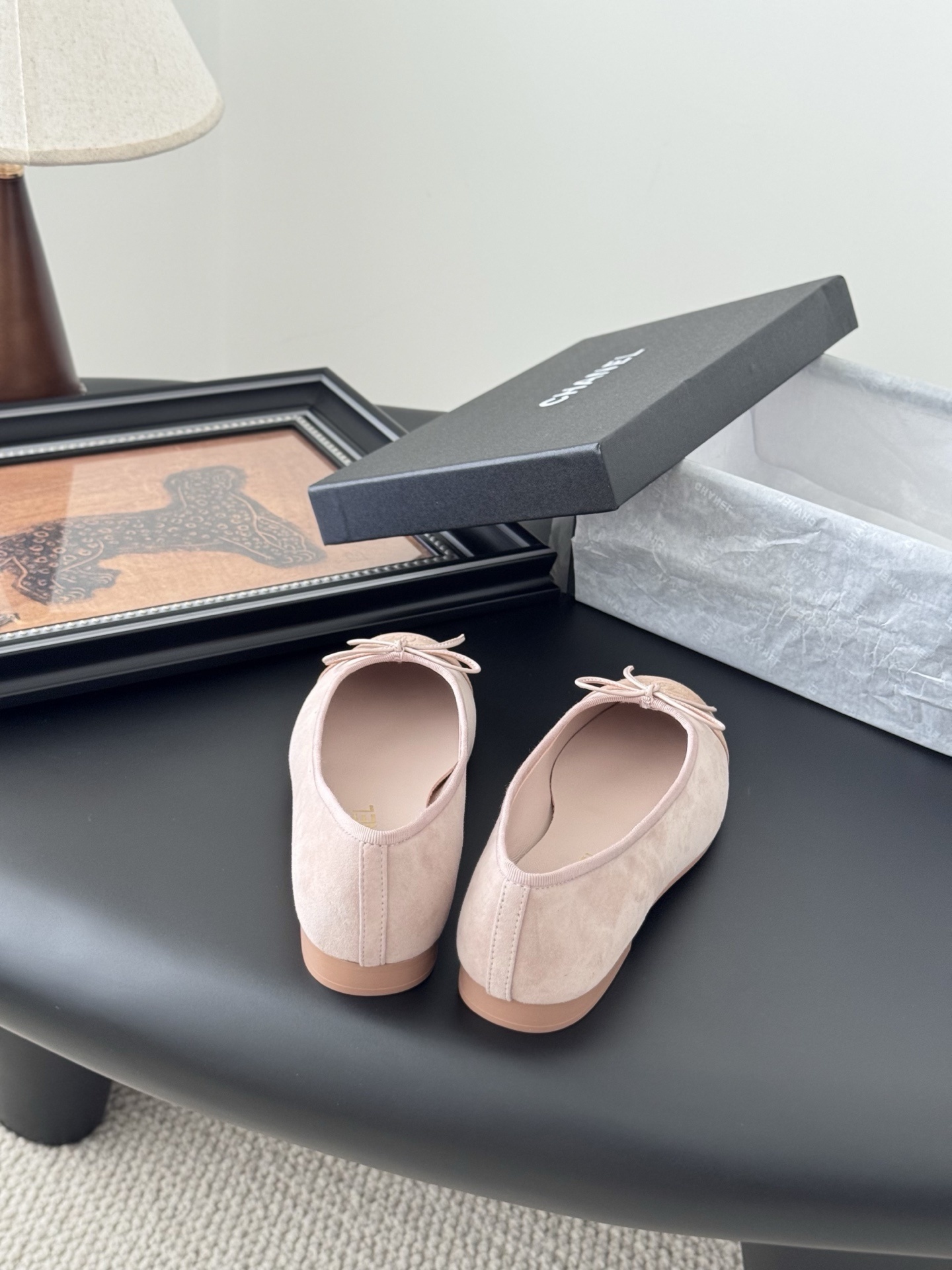 Pair of Chanel pink suede ballet flats with CC logo and bow detail next to a black shoe box - Hình 6