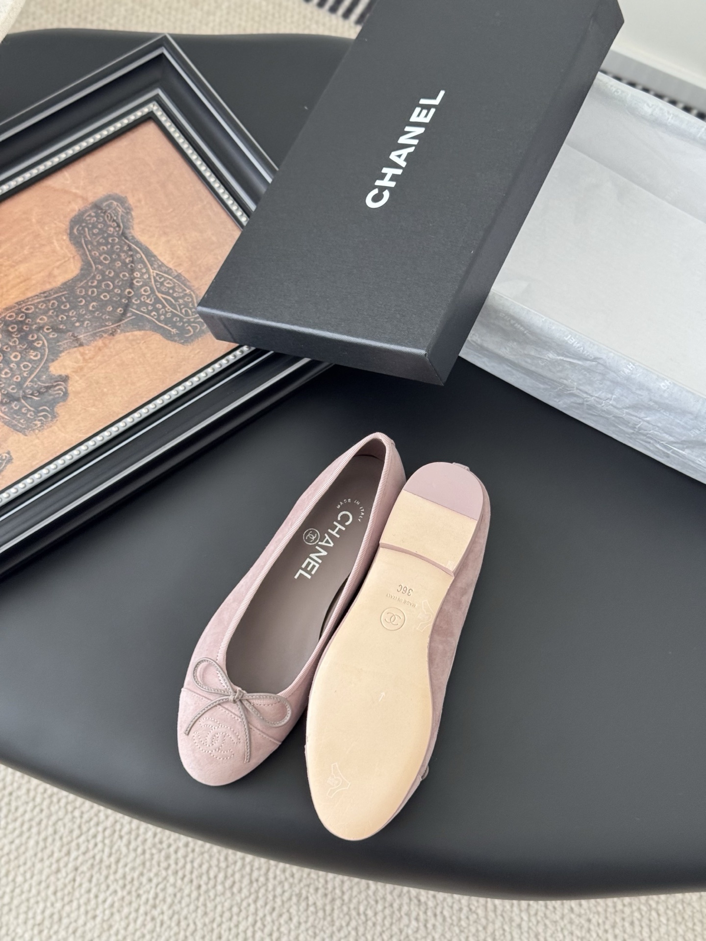 A pair of elegant pink Chanel suede ballet flats with a bow and CC logo on the toe, shown with the original black Chanel box. - Hình 4