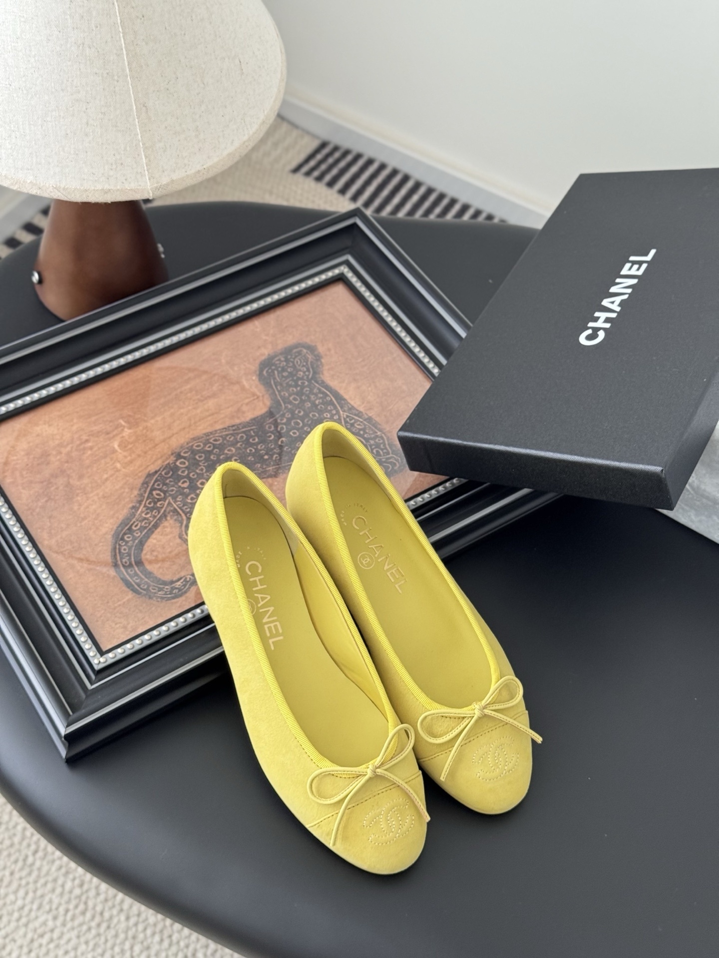 A pair of yellow Chanel suede ballerina flats with a bow and embroidered logo next to their original black box. - Hình 7
