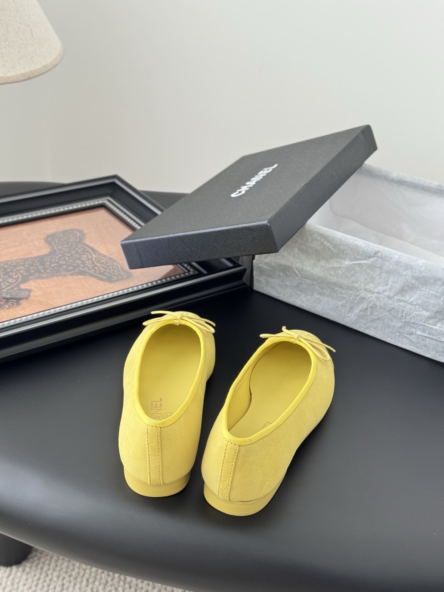 A pair of yellow Chanel suede ballerina flats with a bow and embroidered logo next to their original black box. - Hình 6