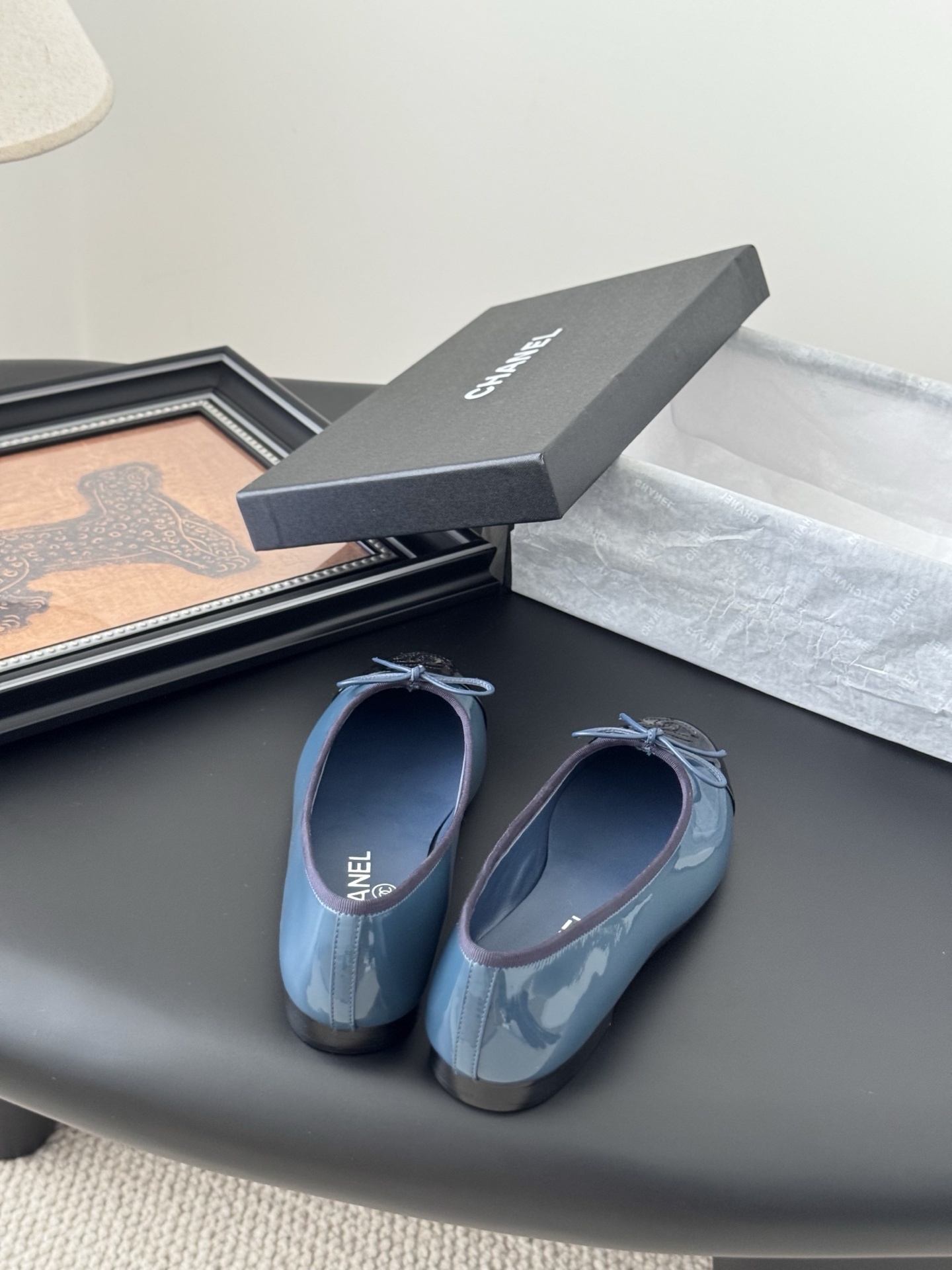 A pair of Chanel two-tone patent leather ballet flats in blue and black with a bow detail and CC logo, displayed with the original Chanel box. - Hình 6