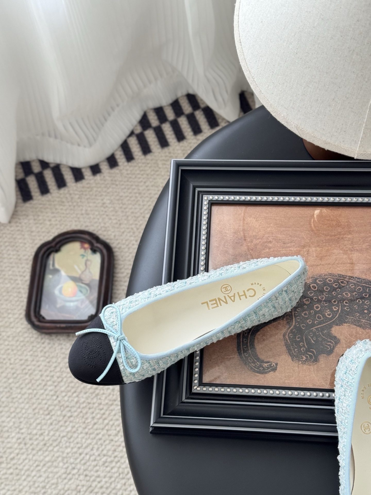 A pair of Chanel light blue tweed ballerina flats with black cap toe and bow detail next to a Chanel luxury box. - Hình 8