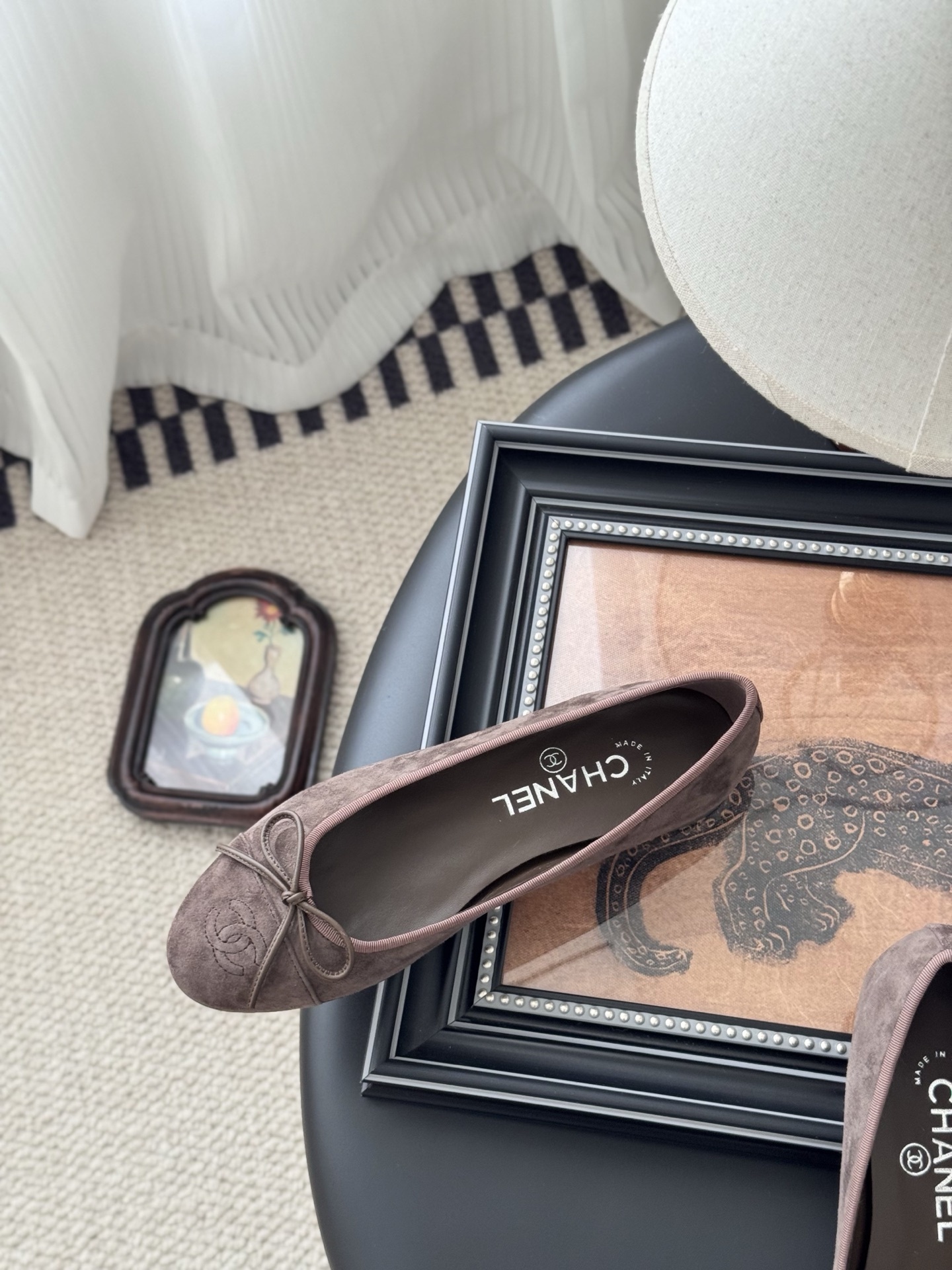 A pair of taupe Chanel suede ballet flats with embroidered CC logo and bow detail next to an original Chanel box - Hình 8