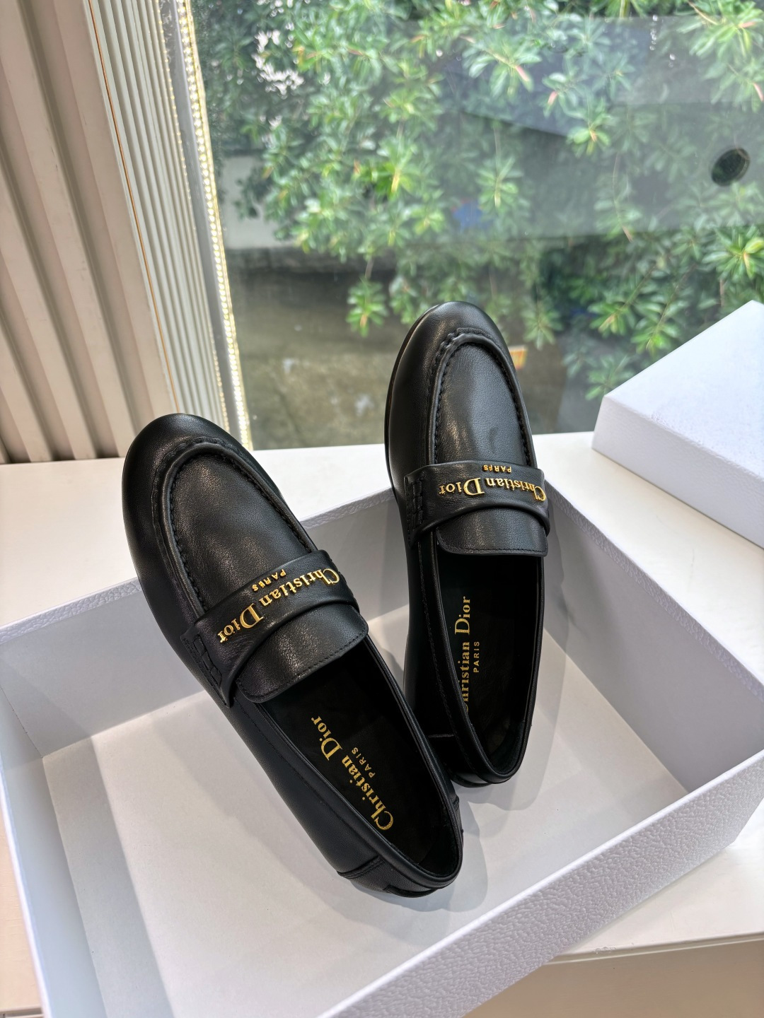 Pair of Christian Dior black leather loafers with gold signature logo in a white box - Hình 2