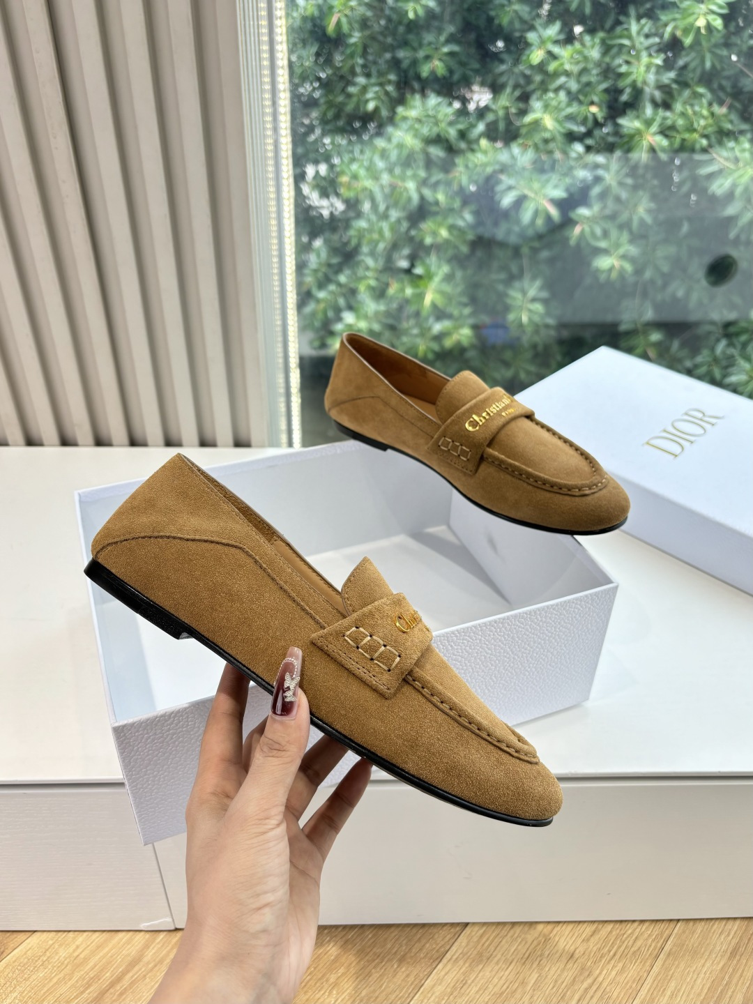 A pair of Christian Dior tan suede loafers with gold logo lettering displayed in a white Dior box. - Hình 3