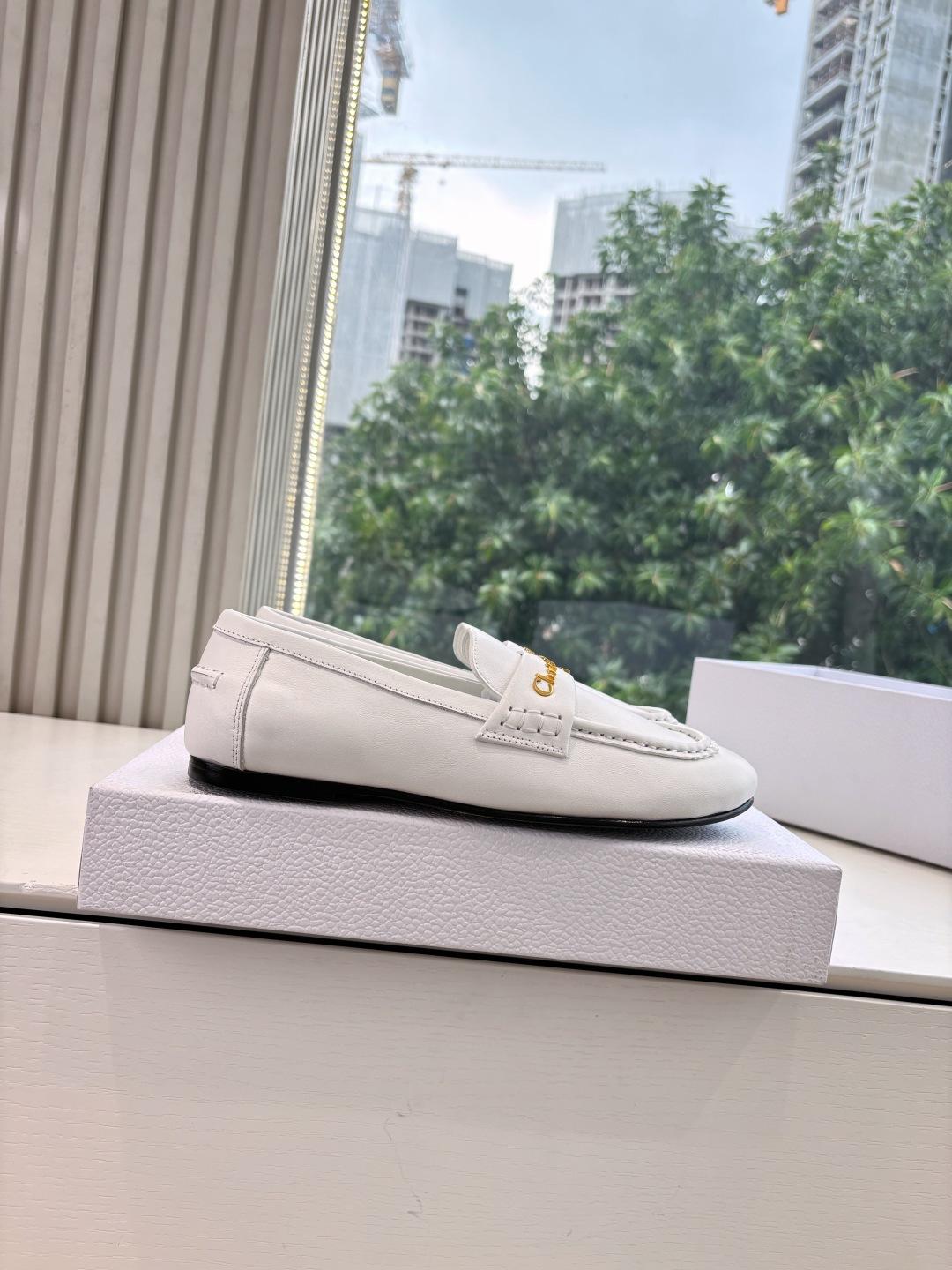A pair of elegant white Christian Dior leather loafers with gold-tone signature logo in a luxury white gift box. - Hình 9