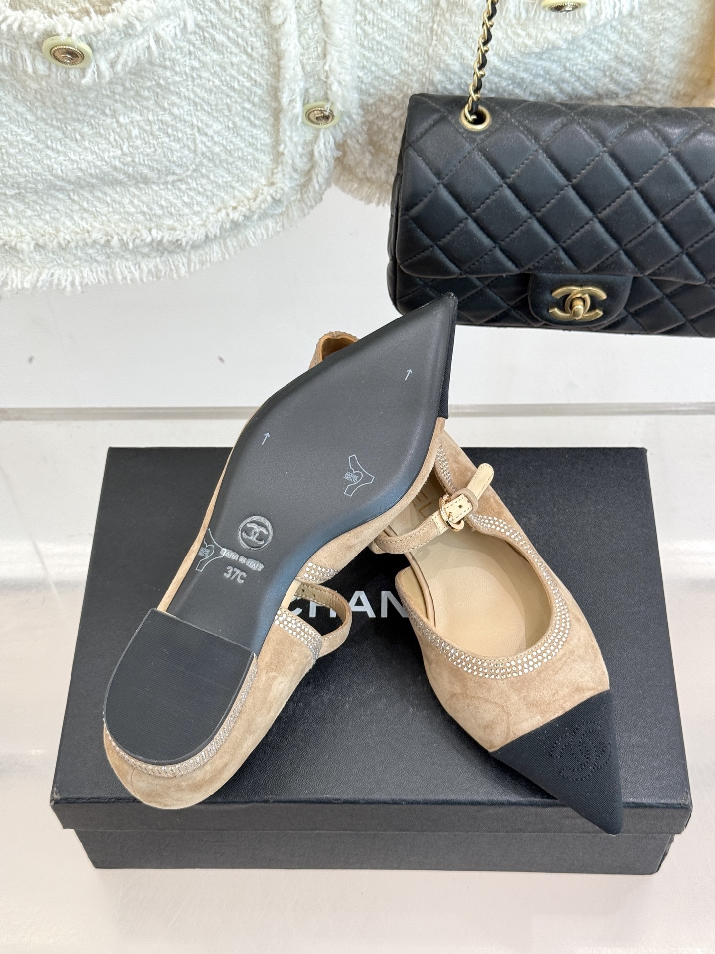 Chanel beige suede Mary Jane flats with black pointed cap-toes and crystal rhinestone trim displayed on a black box. - Hình 9