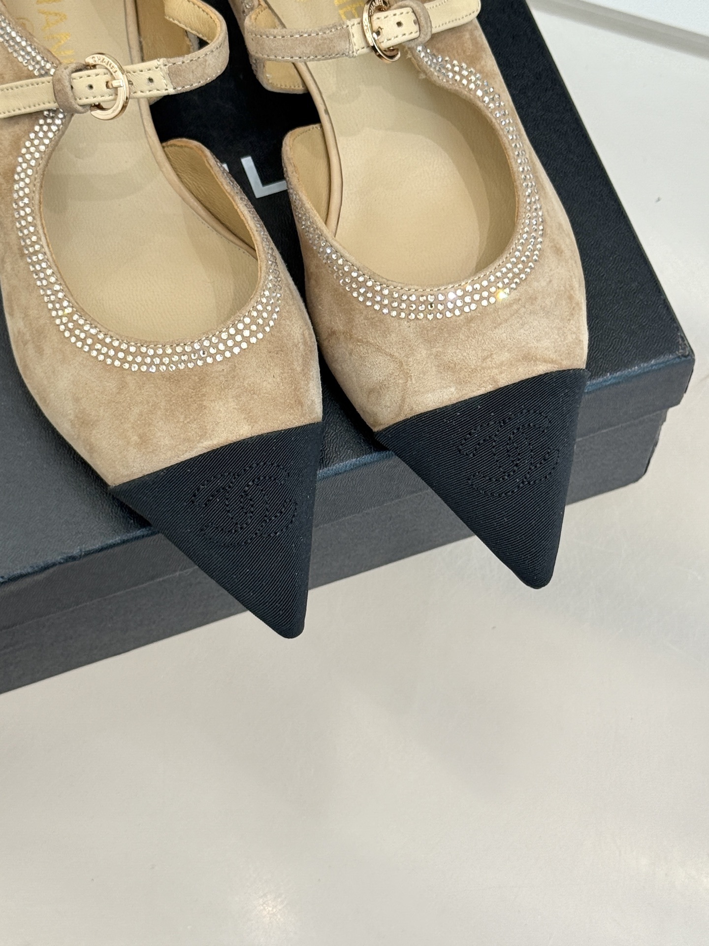 Chanel beige suede Mary Jane flats with black pointed cap-toes and crystal rhinestone trim displayed on a black box. - Hình 7