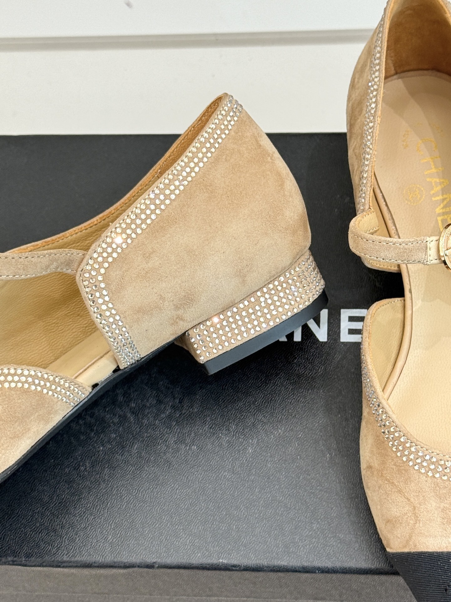 Chanel beige suede Mary Jane flats with black pointed cap-toes and crystal rhinestone trim displayed on a black box. - Hình 6