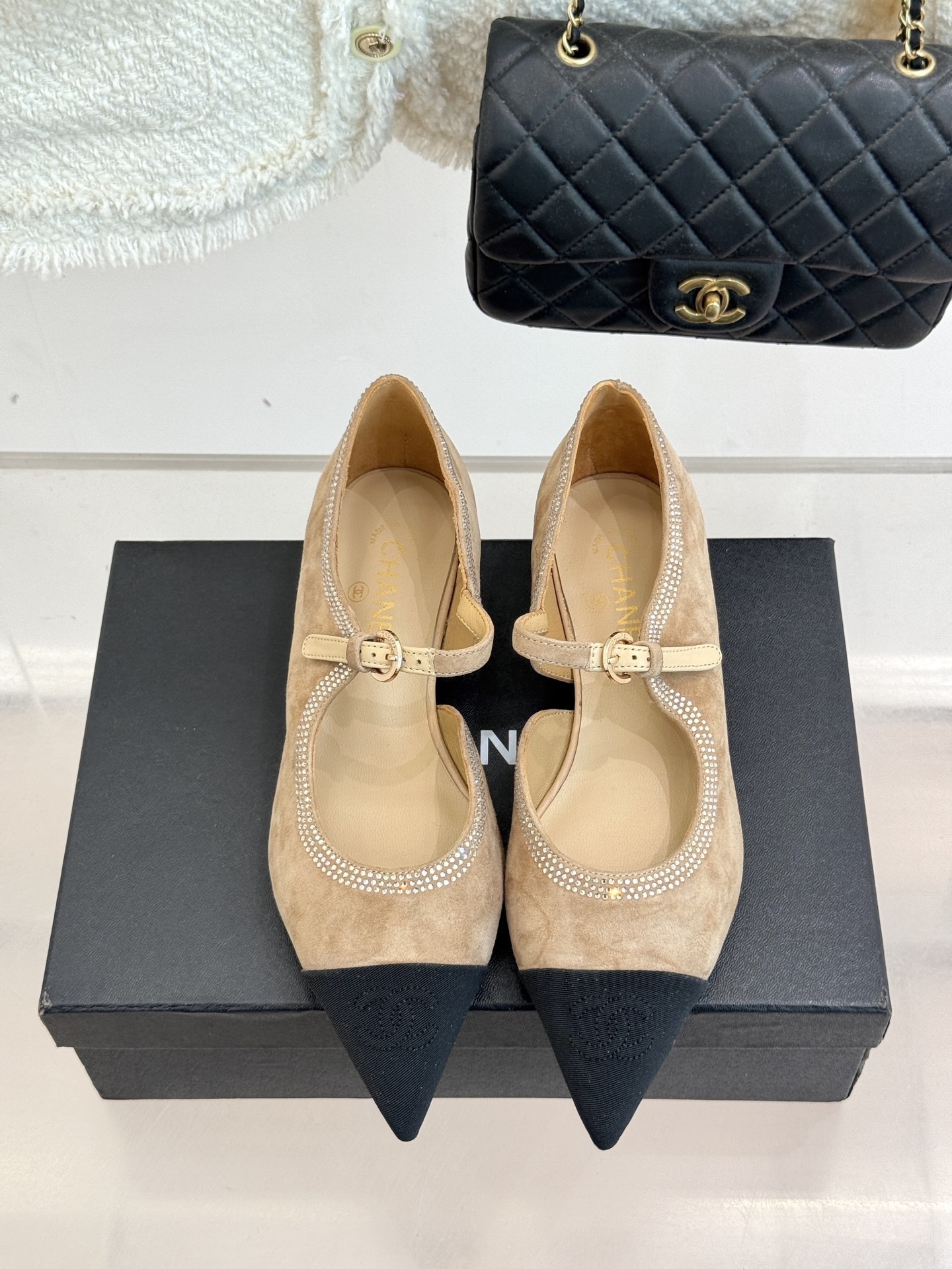 Chanel beige suede Mary Jane flats with black pointed cap-toes and crystal rhinestone trim displayed on a black box. - Hình 4