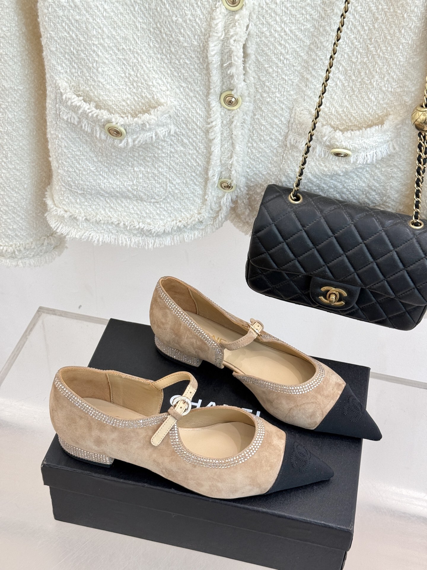 Chanel beige suede Mary Jane flats with black pointed cap-toes and crystal rhinestone trim displayed on a black box. - Hình 3