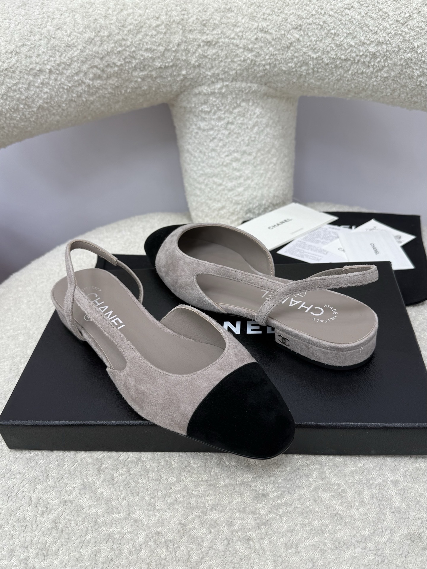 A pair of Chanel two-tone grey and black suede slingback flats displayed with branded dust bags and authentication papers. - Hình 7