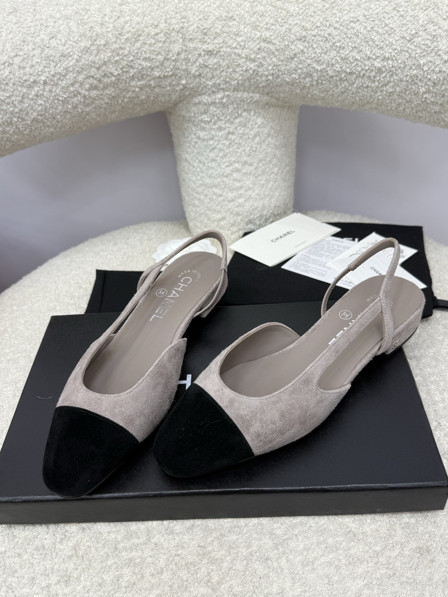 A pair of Chanel two-tone grey and black suede slingback flats displayed with branded dust bags and authentication papers. - Hình 5
