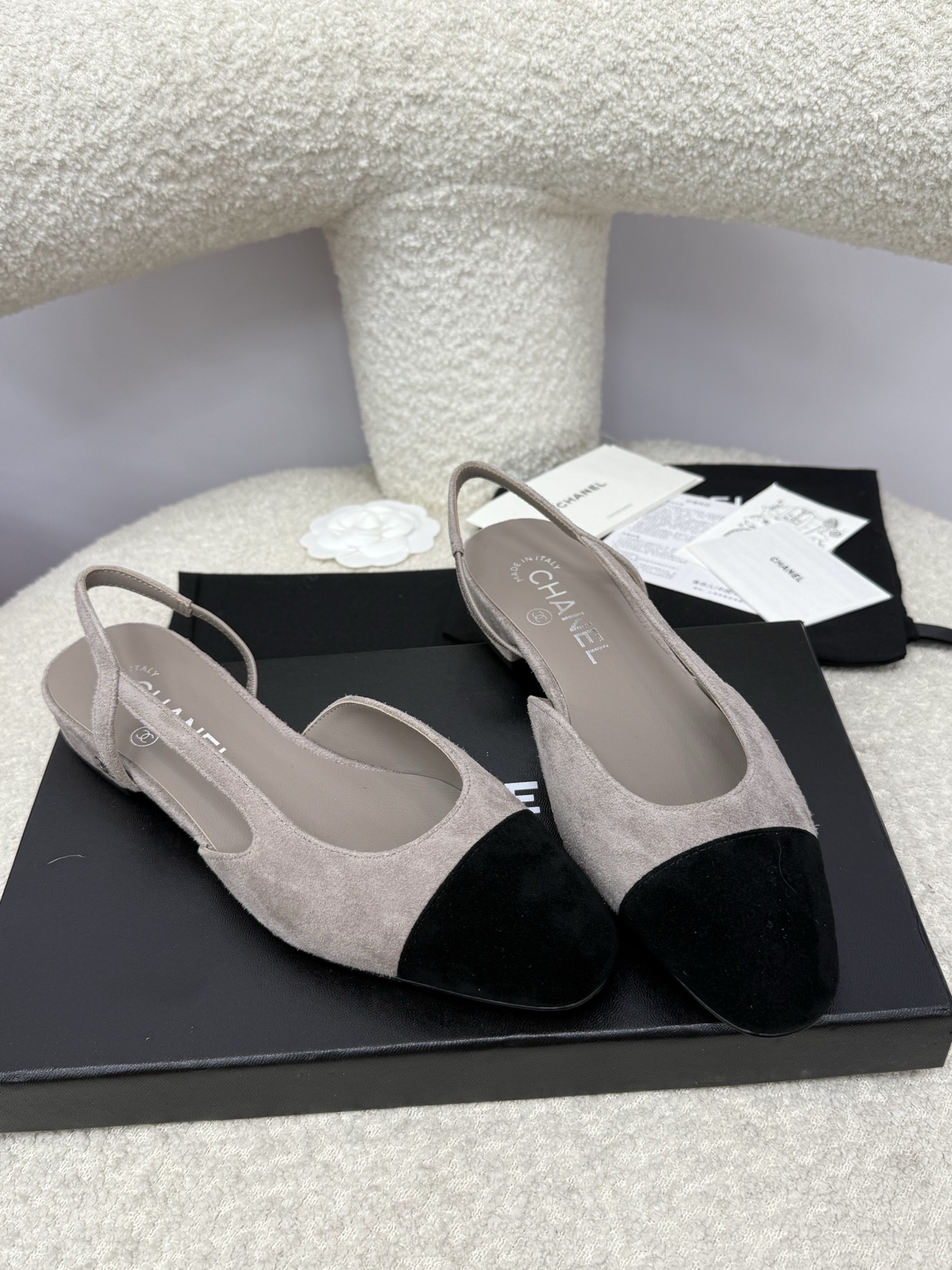A pair of Chanel two-tone grey and black suede slingback flats displayed with branded dust bags and authentication papers. - Hình 4
