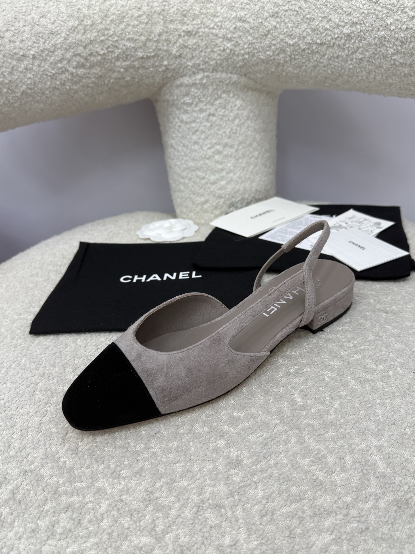 A pair of Chanel two-tone grey and black suede slingback flats displayed with branded dust bags and authentication papers. - Hình 3