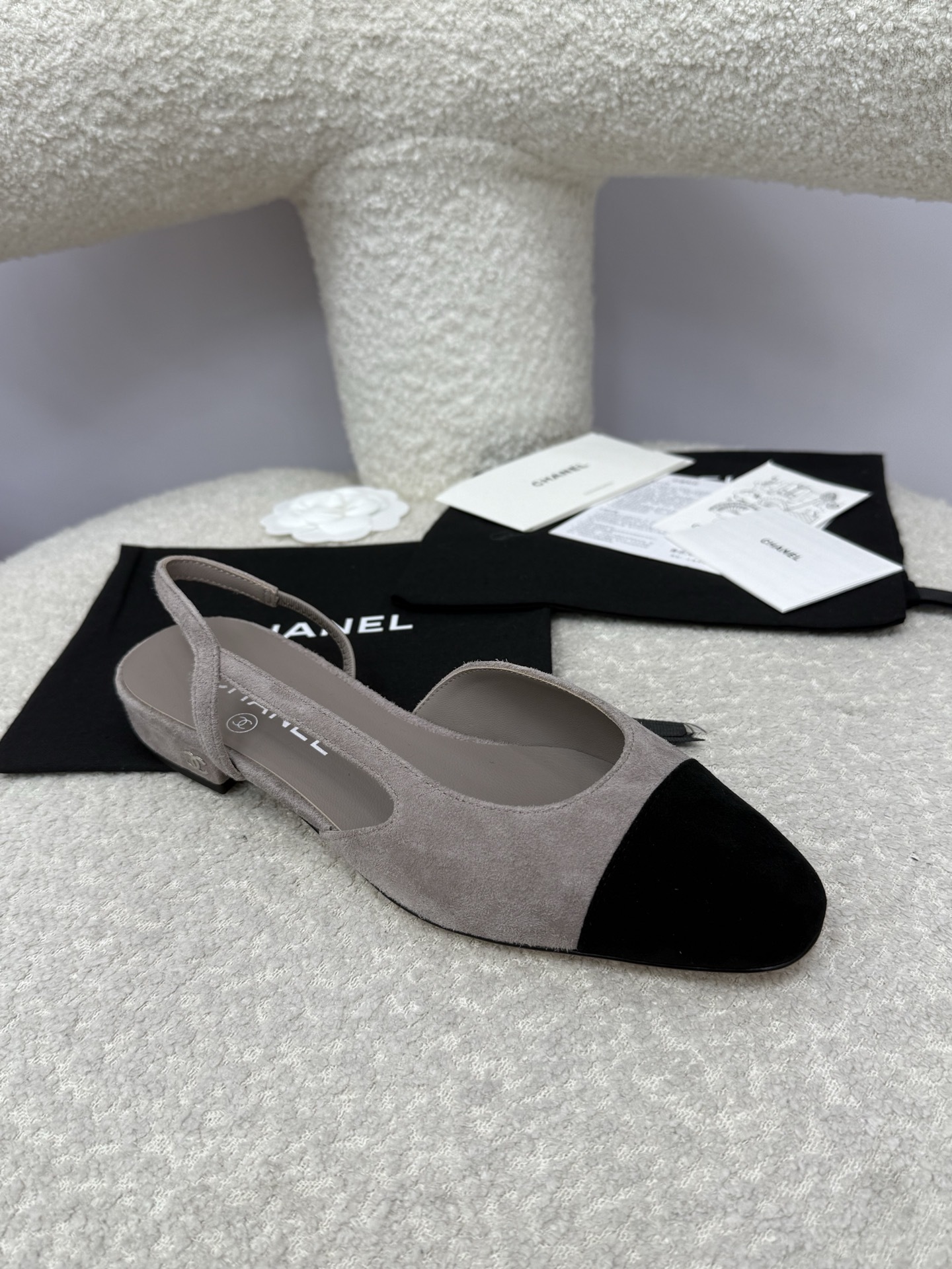 A pair of Chanel two-tone grey and black suede slingback flats displayed with branded dust bags and authentication papers. - Hình 2