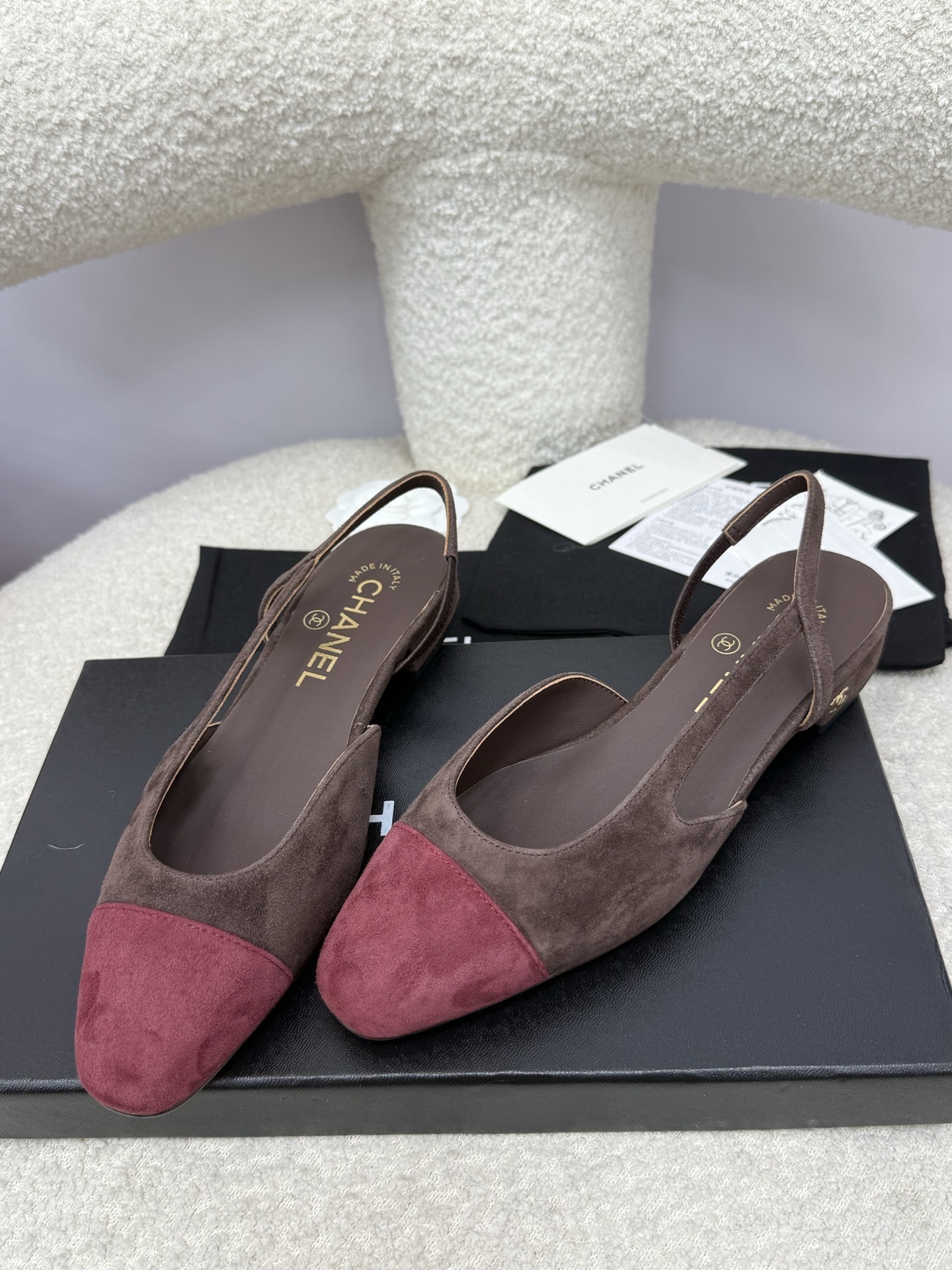 Pair of Chanel two-tone slingback flats in brown suede with burgundy cap toe on a white textured surface with packaging. - Hình 6