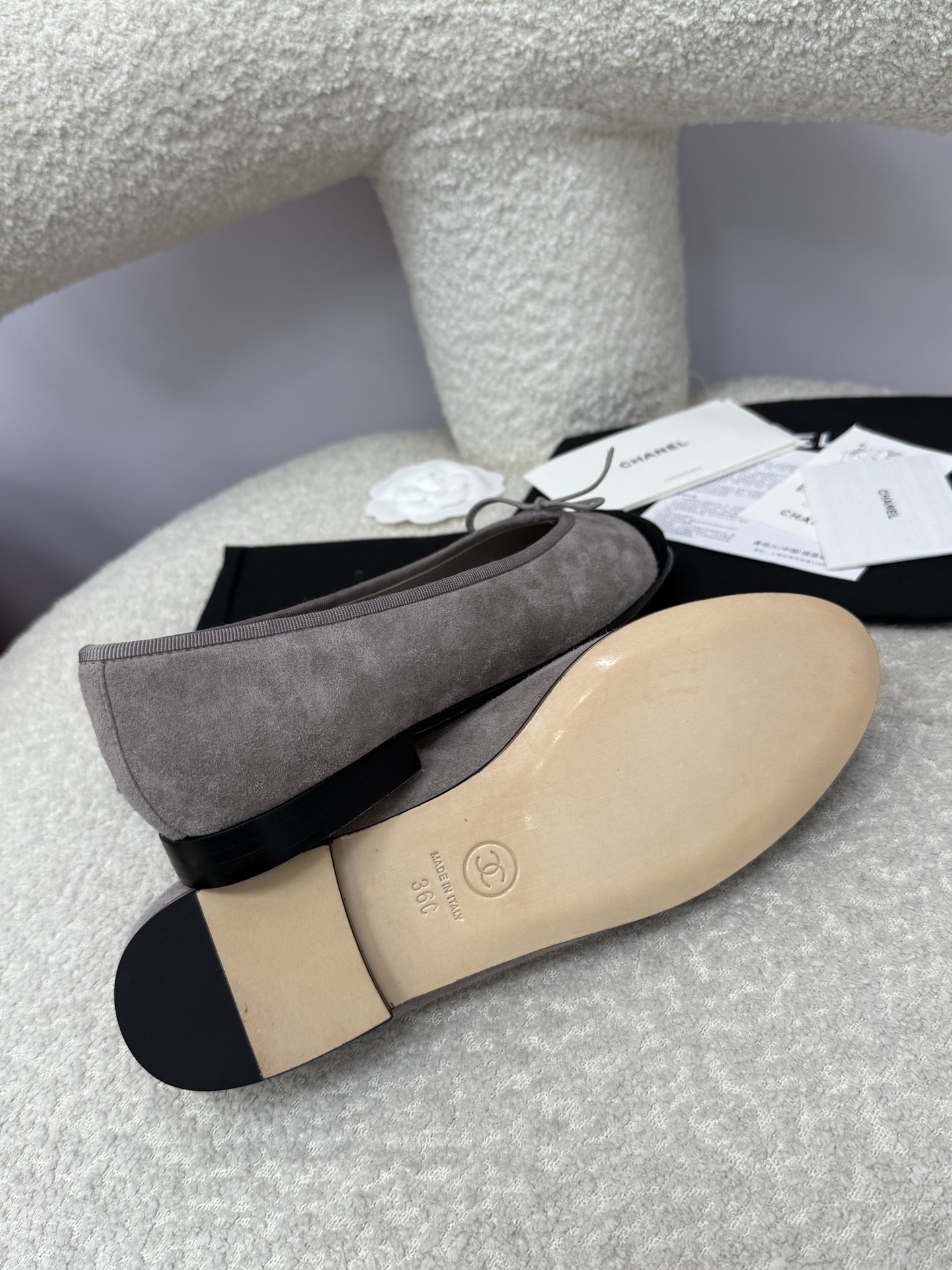 Pair of Chanel grey suede ballerina flats with black suede cap-toe and bow detail on a white textured surface. - Hình 8