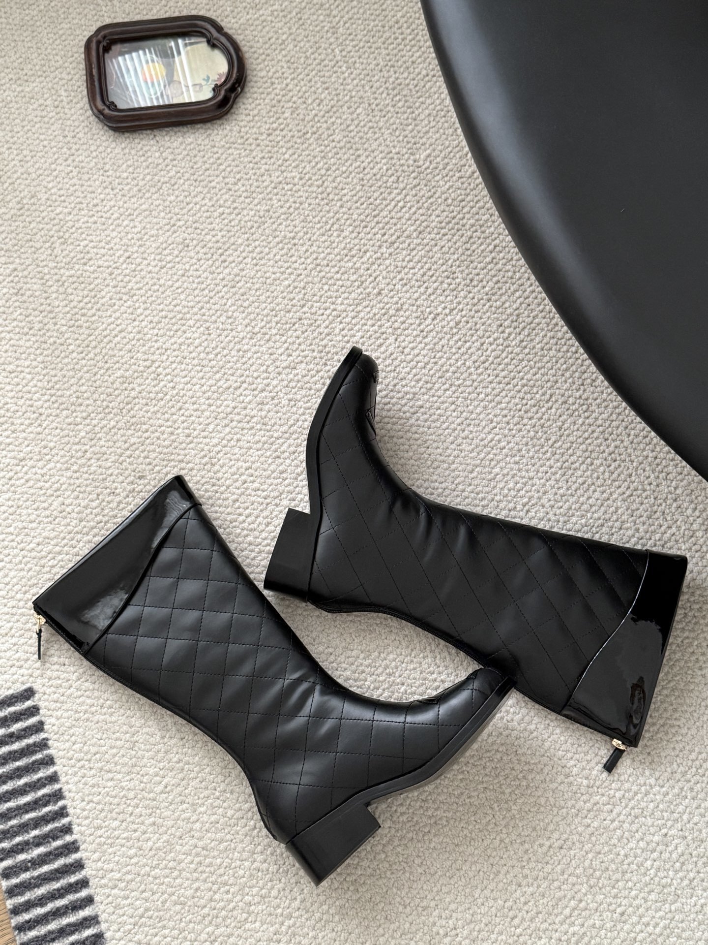 Pair of black Chanel quilted leather knee-high boots with CC logo on the toe and patent leather trim. - Hình 9