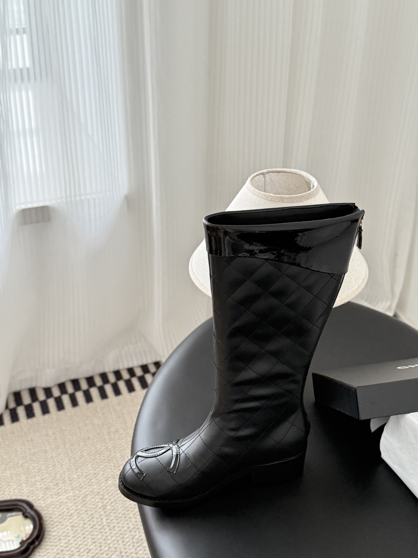 Pair of black Chanel quilted leather knee-high boots with CC logo on the toe and patent leather trim. - Hình 7
