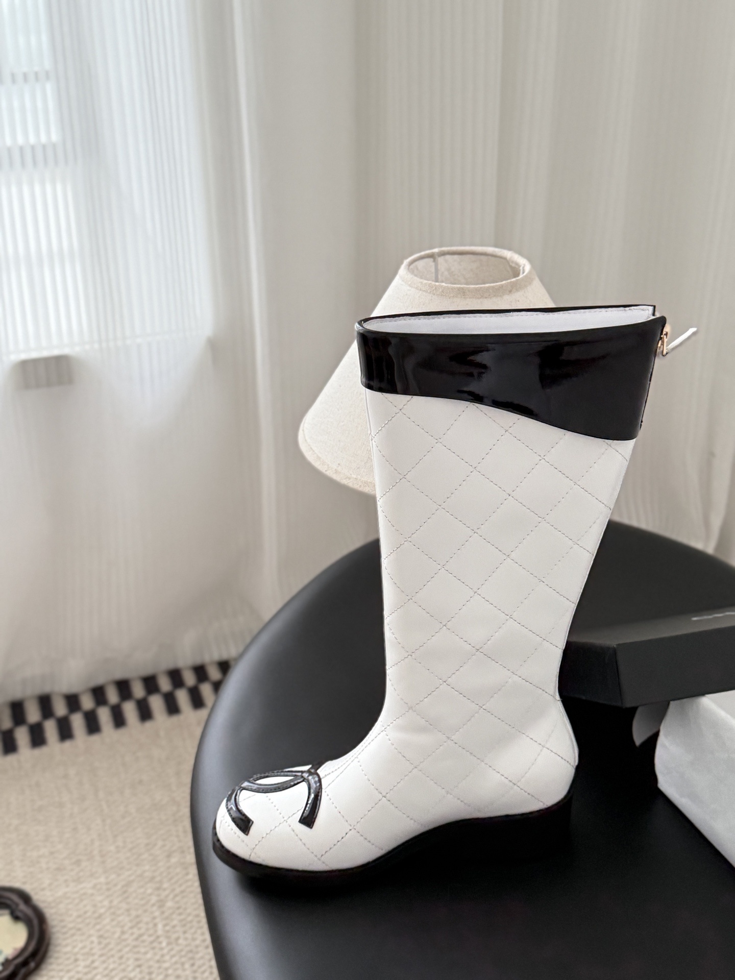 Pair of luxury white quilted leather knee-high boots with black patent trim and iconic logo on the toe. - Hình 8