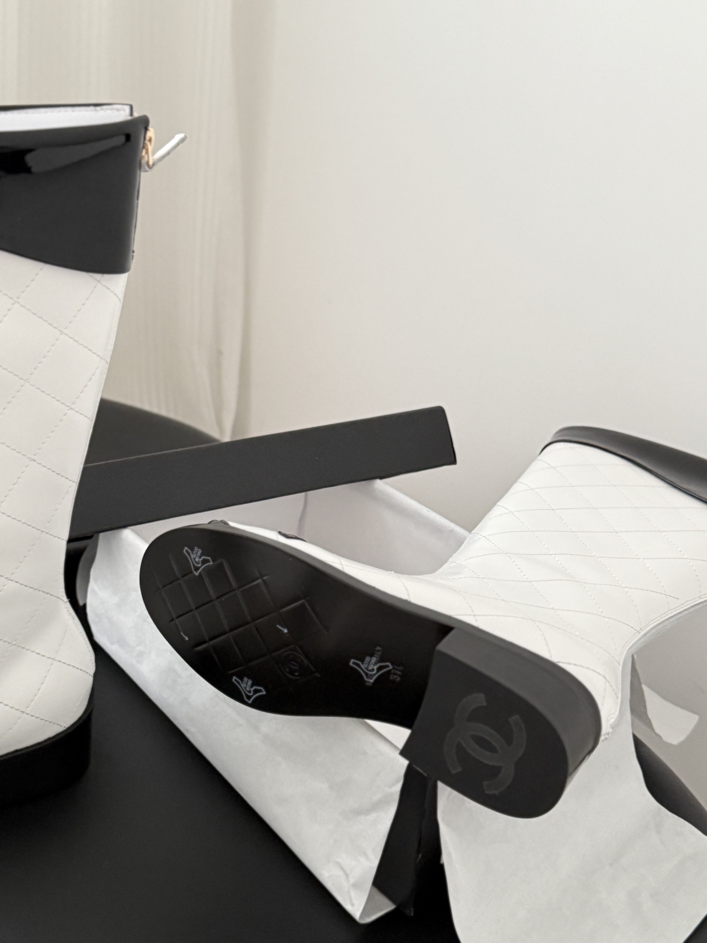 Pair of luxury white quilted leather knee-high boots with black patent trim and iconic logo on the toe. - Hình 5