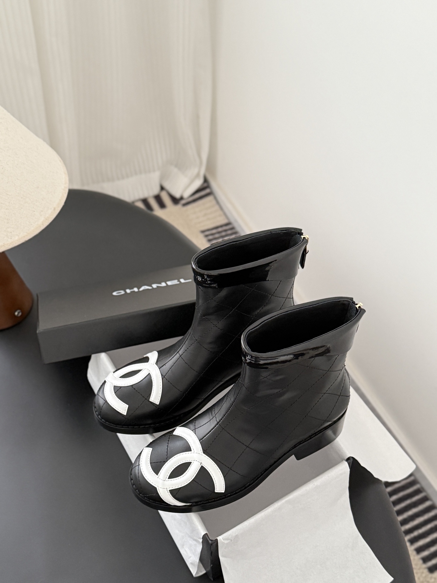 Pair of Chanel black quilted leather ankle boots with large white interlocking CC logos on the toes and gold back zippers. - Hình 9