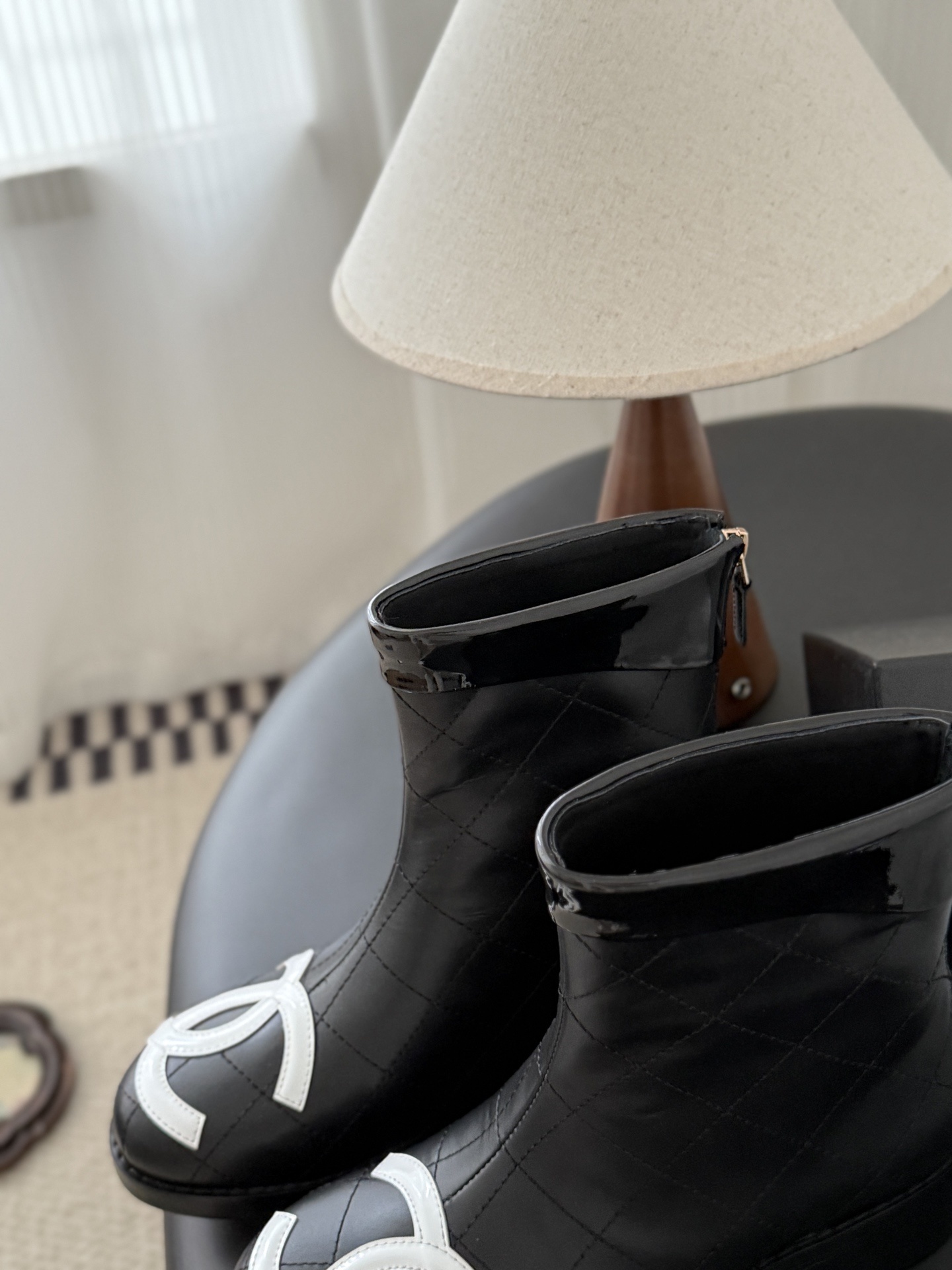 Pair of Chanel black quilted leather ankle boots with large white interlocking CC logos on the toes and gold back zippers. - Hình 7