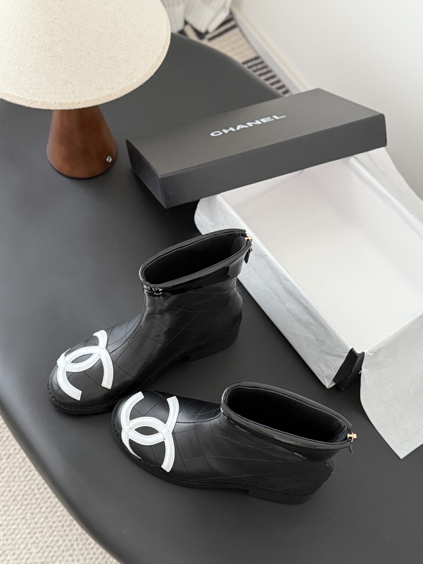 Pair of Chanel black quilted leather ankle boots with large white interlocking CC logos on the toes and gold back zippers. - Hình 6