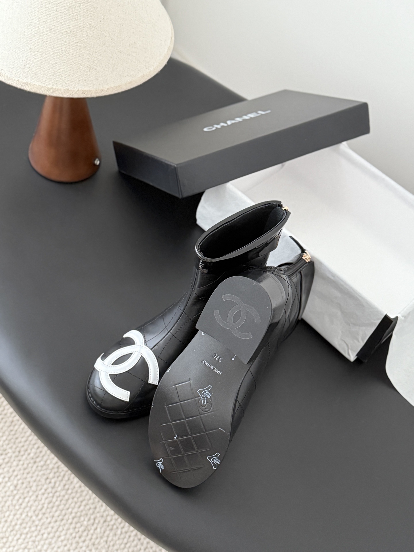 Pair of Chanel black quilted leather ankle boots with large white interlocking CC logos on the toes and gold back zippers. - Hình 5