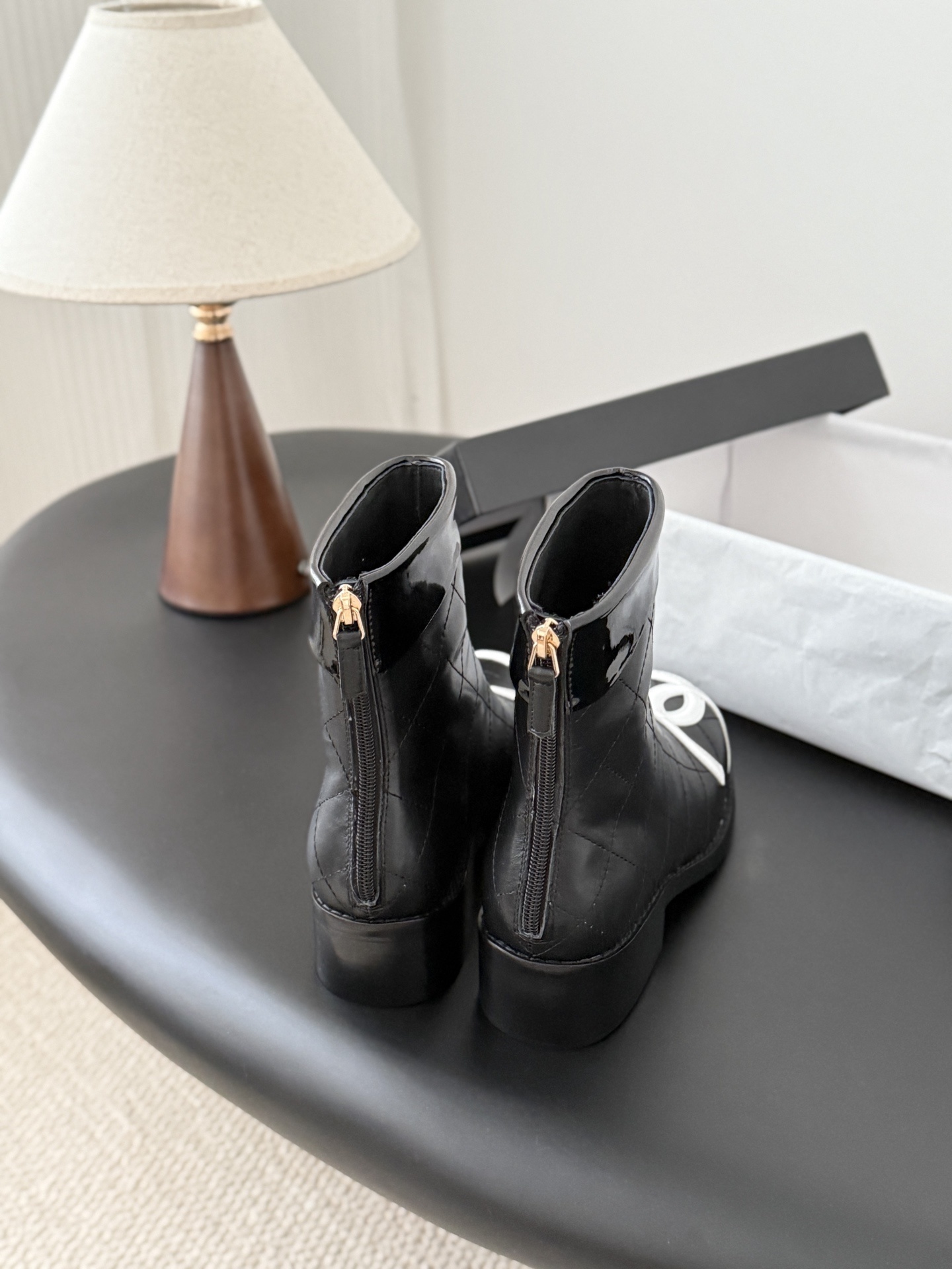 Pair of Chanel black quilted leather ankle boots with large white interlocking CC logos on the toes and gold back zippers. - Hình 3