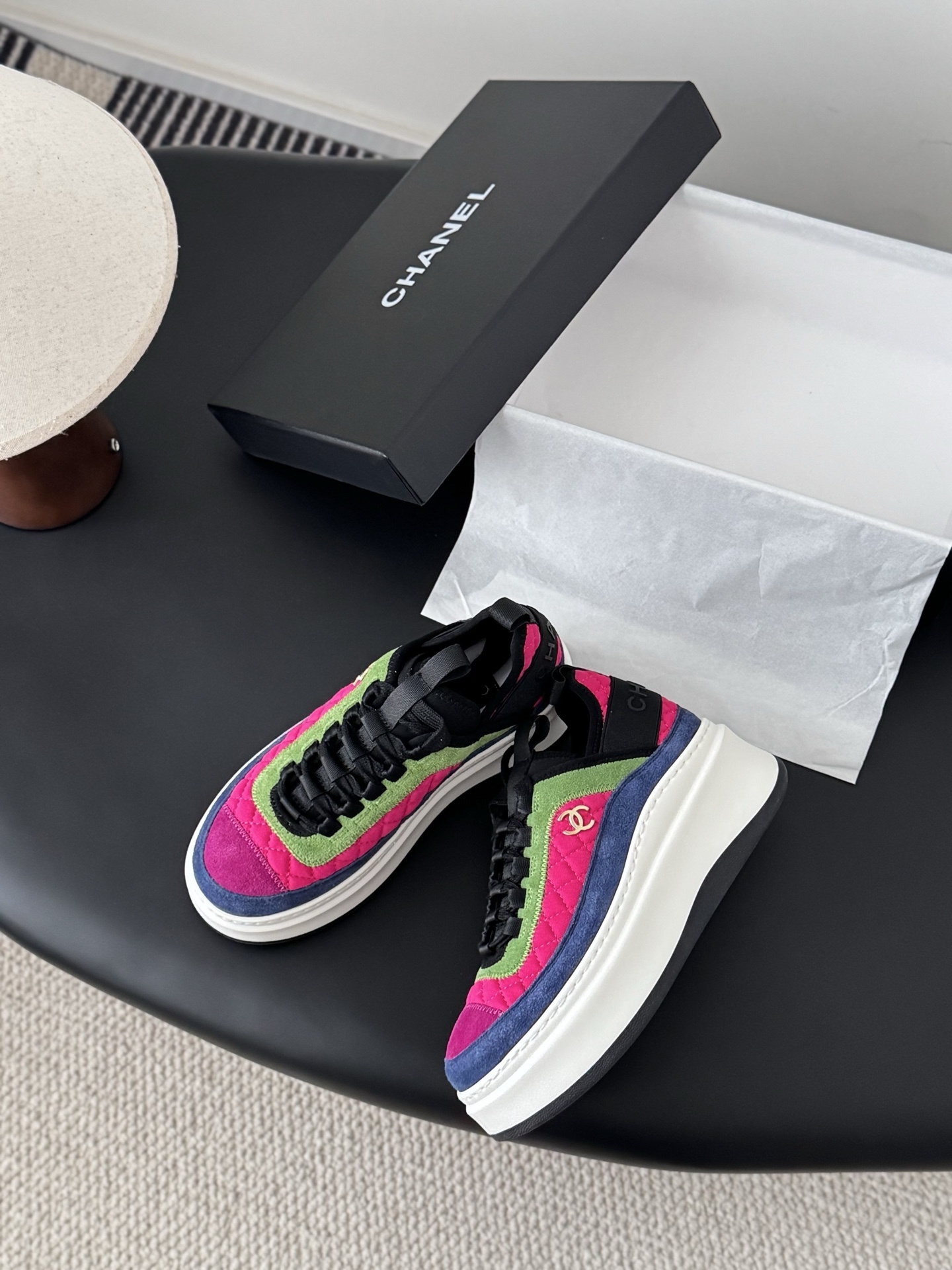 A pair of Chanel multicolor platform sneakers with pink, green, and blue quilted panels next to a black Chanel box. - Hình 3