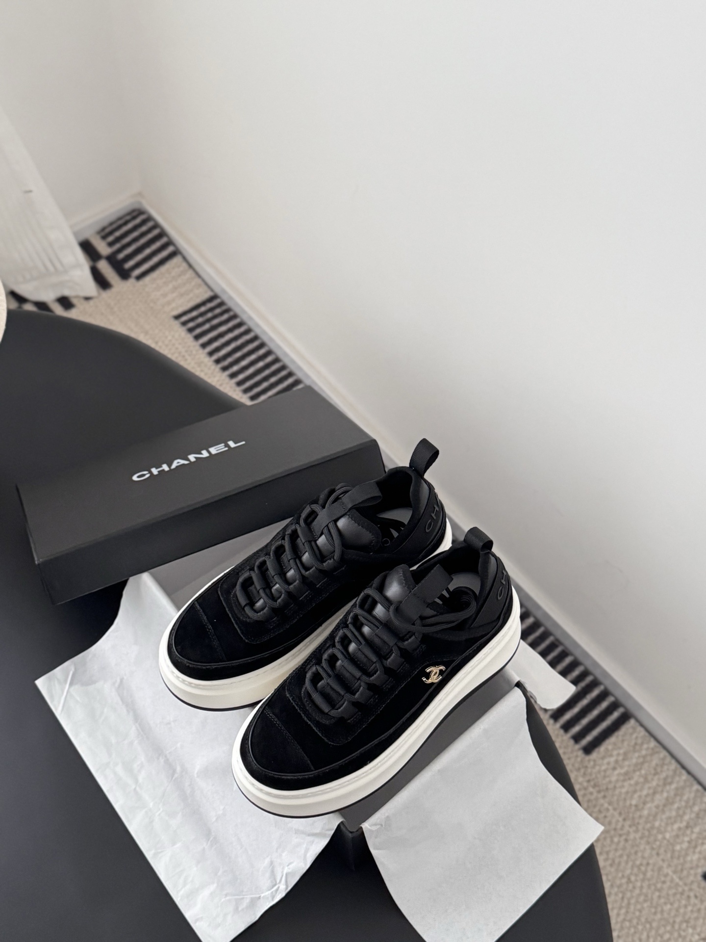 Pair of black Chanel suede platform sneakers with chunky white soles and gold CC logo next to a Chanel shoe box - Hình 6