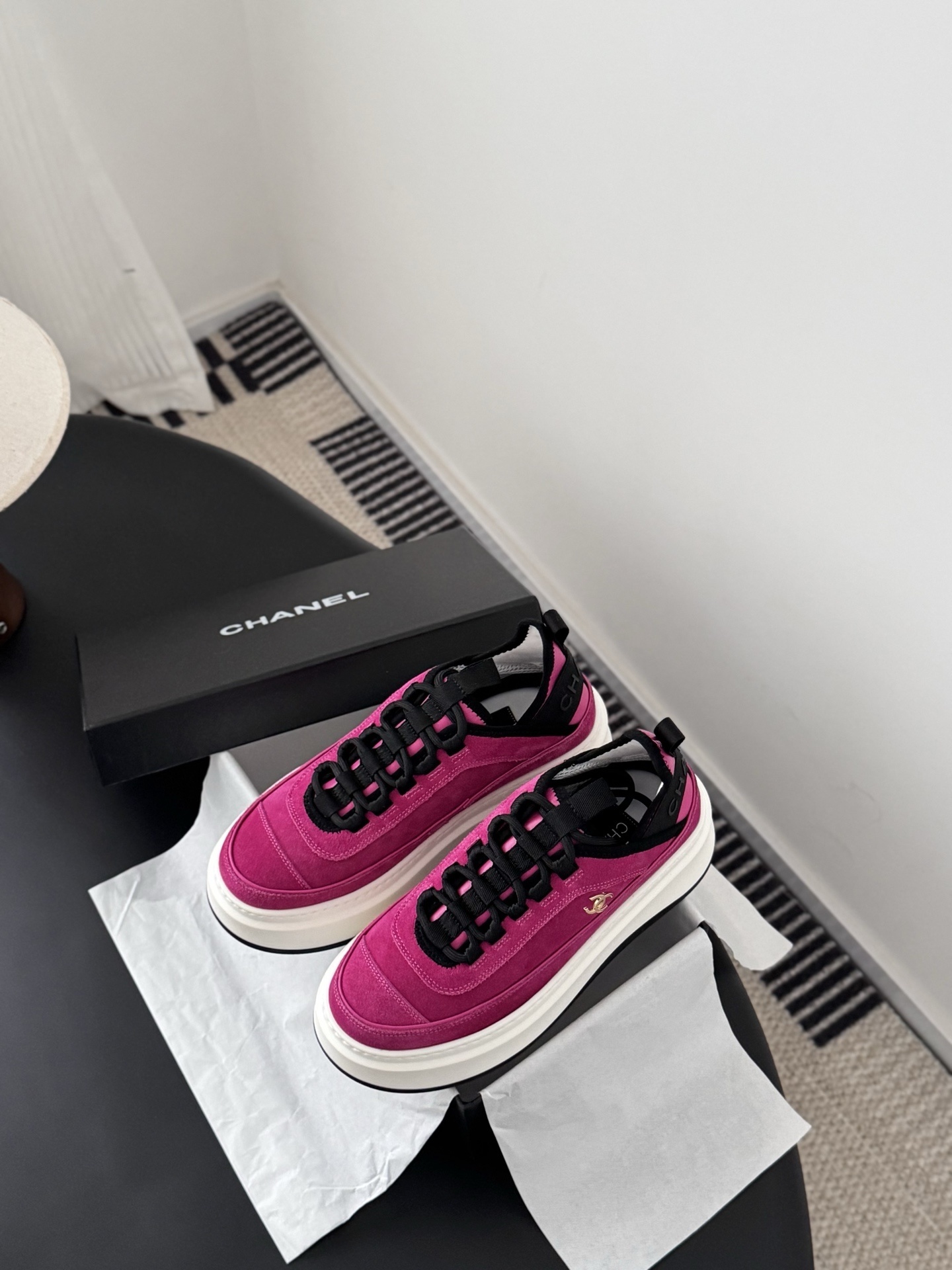 Pair of vibrant Chanel pink suede platform sneakers with gold CC logo displayed next to a black Chanel brand box. - Hình 6