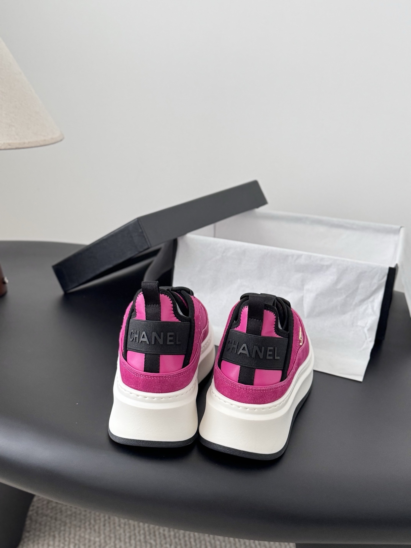 Pair of vibrant Chanel pink suede platform sneakers with gold CC logo displayed next to a black Chanel brand box. - Hình 5