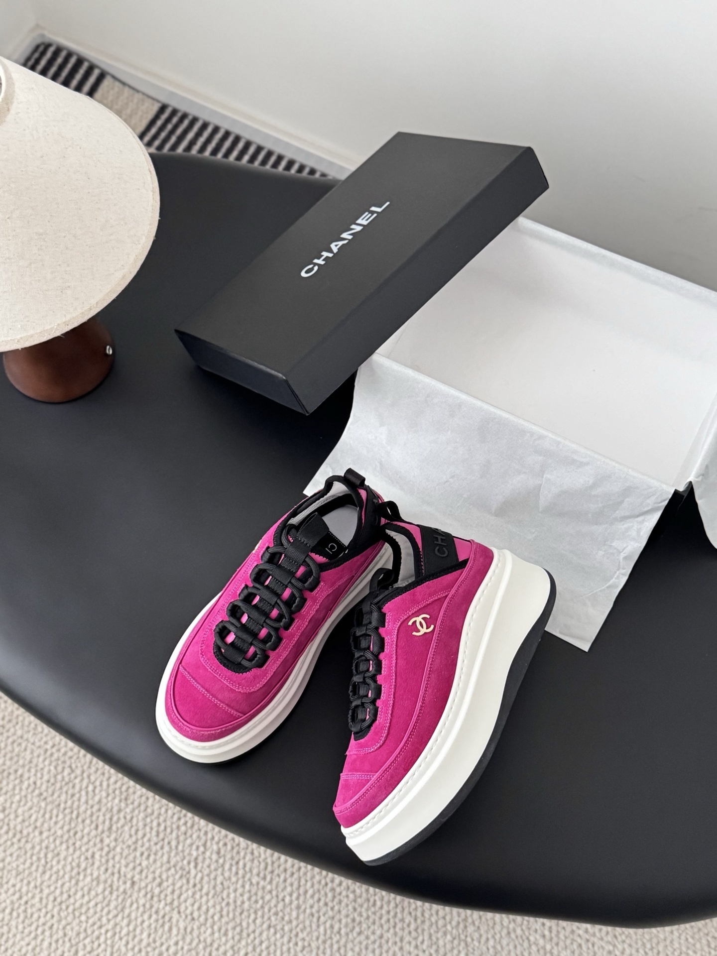 Pair of vibrant Chanel pink suede platform sneakers with gold CC logo displayed next to a black Chanel brand box. - Hình 3