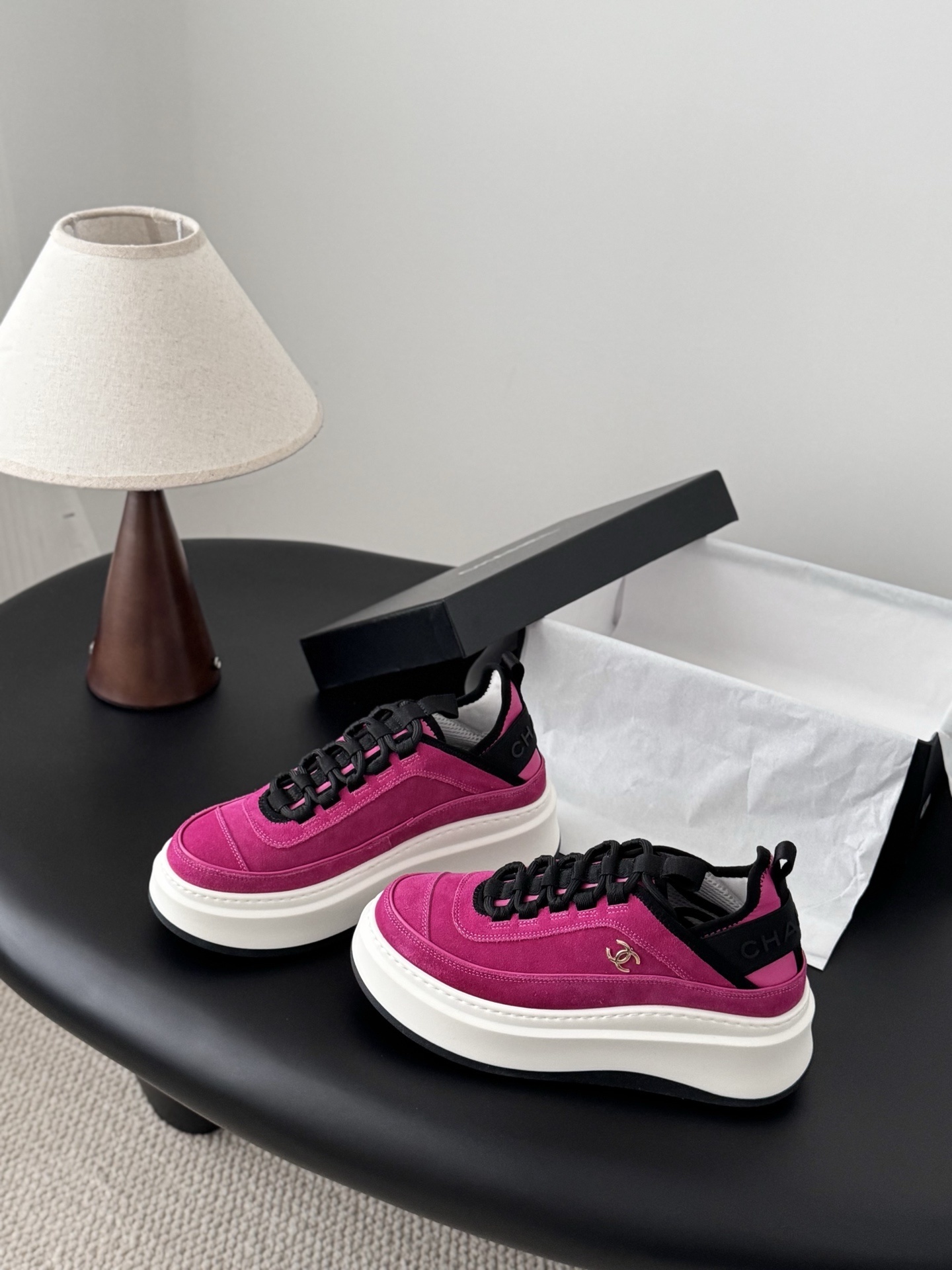 Pair of vibrant Chanel pink suede platform sneakers with gold CC logo displayed next to a black Chanel brand box. - Hình 2