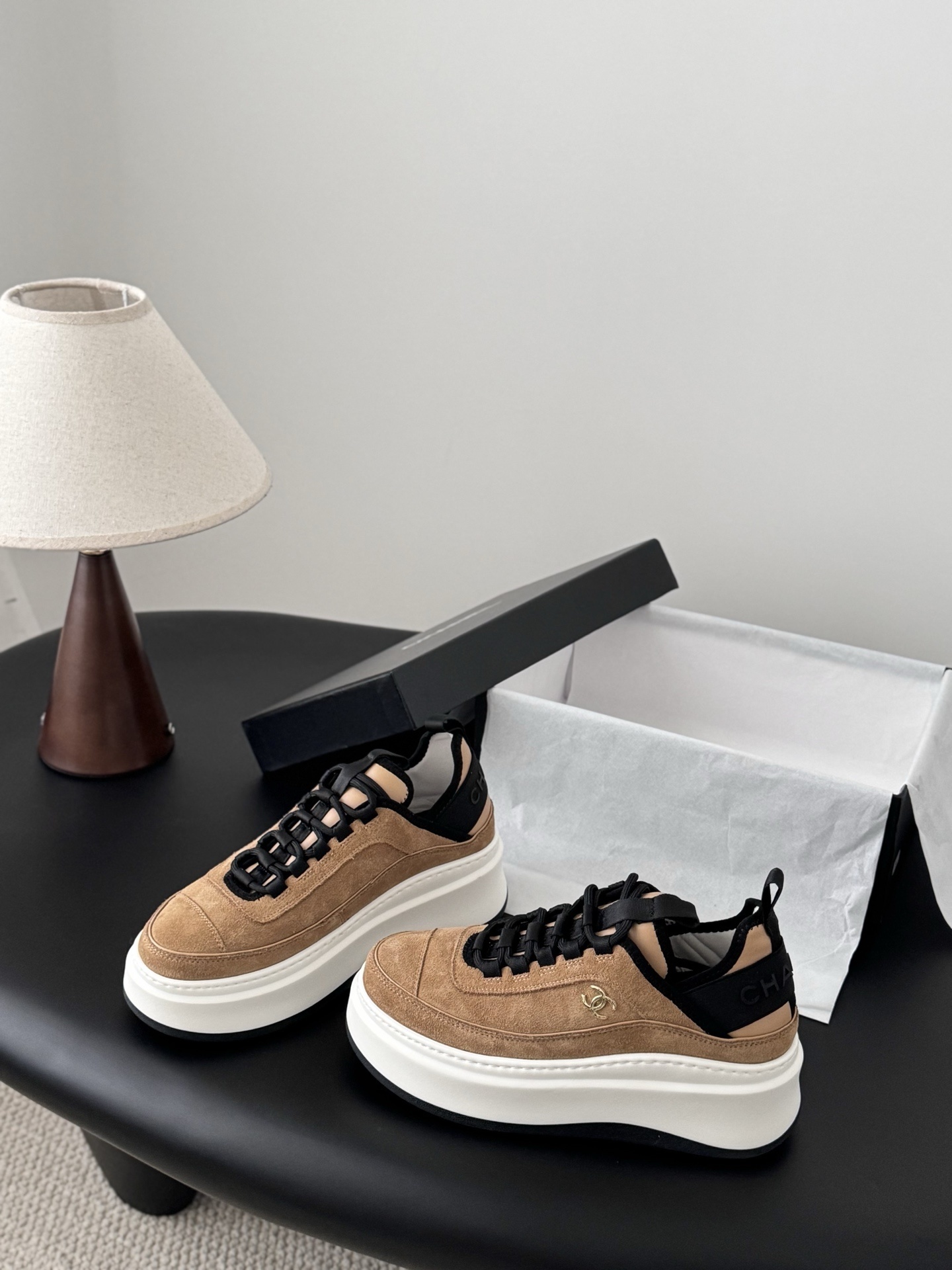 Pair of Chanel tan suede platform sneakers with black laces and thick white soles, featuring a gold CC logo on the side. - Hình 2