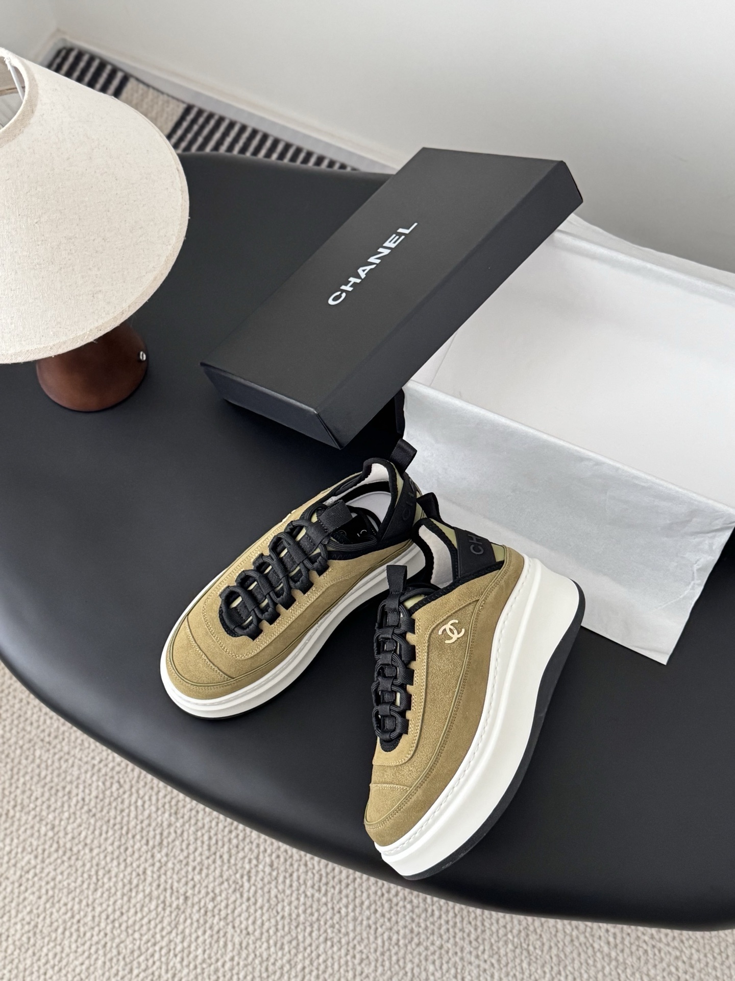 Chanel olive green suede platform sneakers with black accents and white chunky soles next to a black Chanel box. - Hình 3
