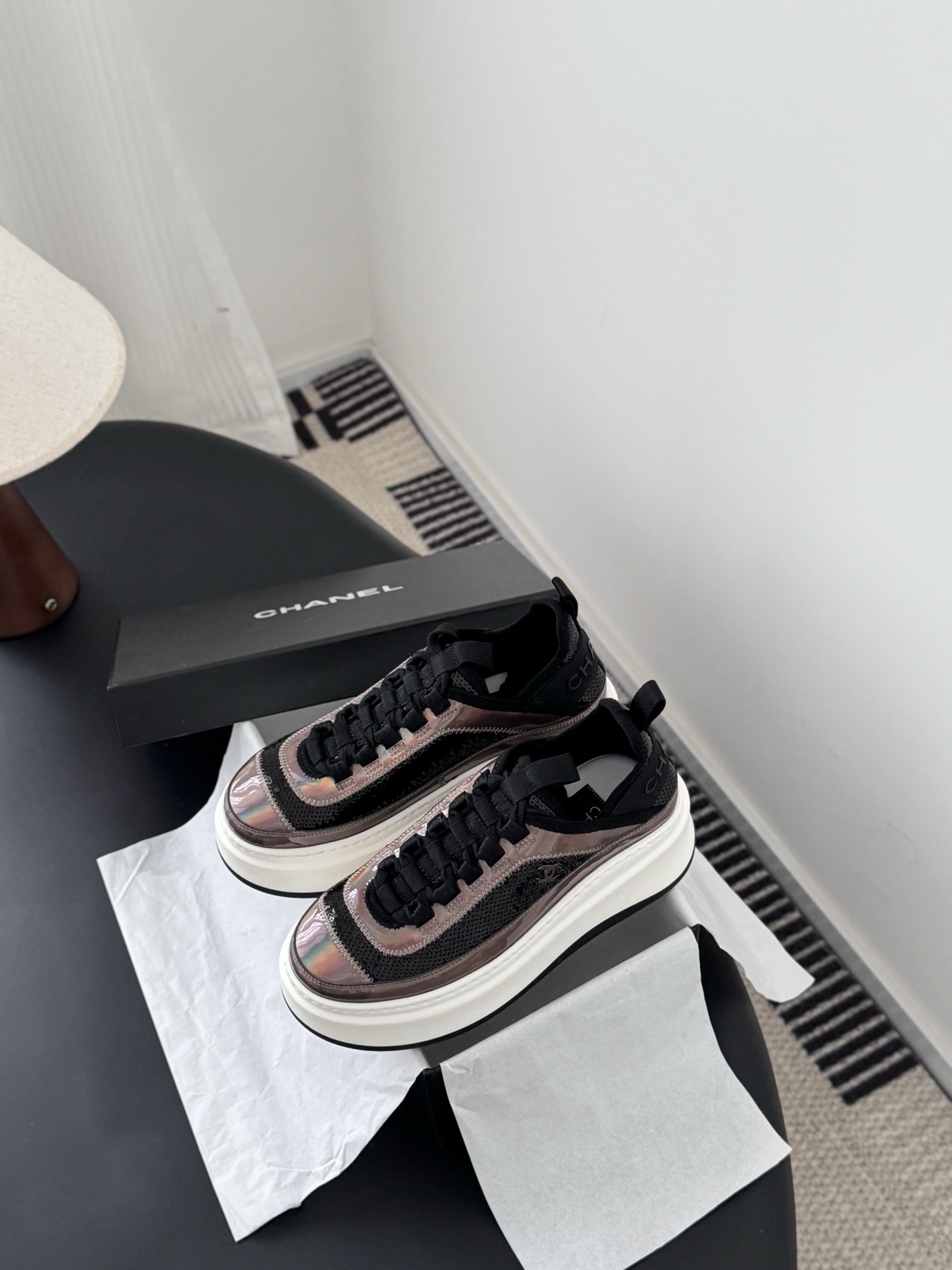 Pair of luxury Chanel platform sneakers with iridescent pink and black sequin details next to a black Chanel box - Hình 6