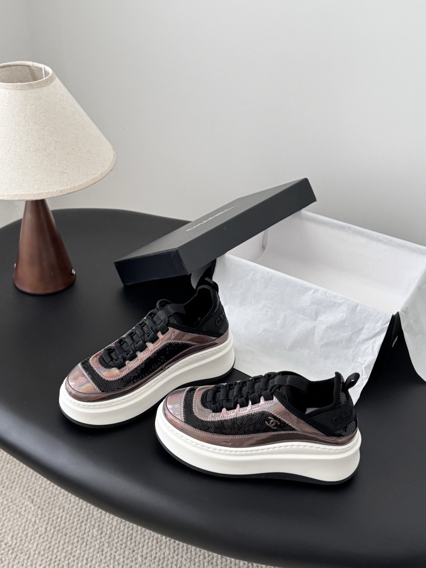 Pair of luxury Chanel platform sneakers with iridescent pink and black sequin details next to a black Chanel box - Hình 2