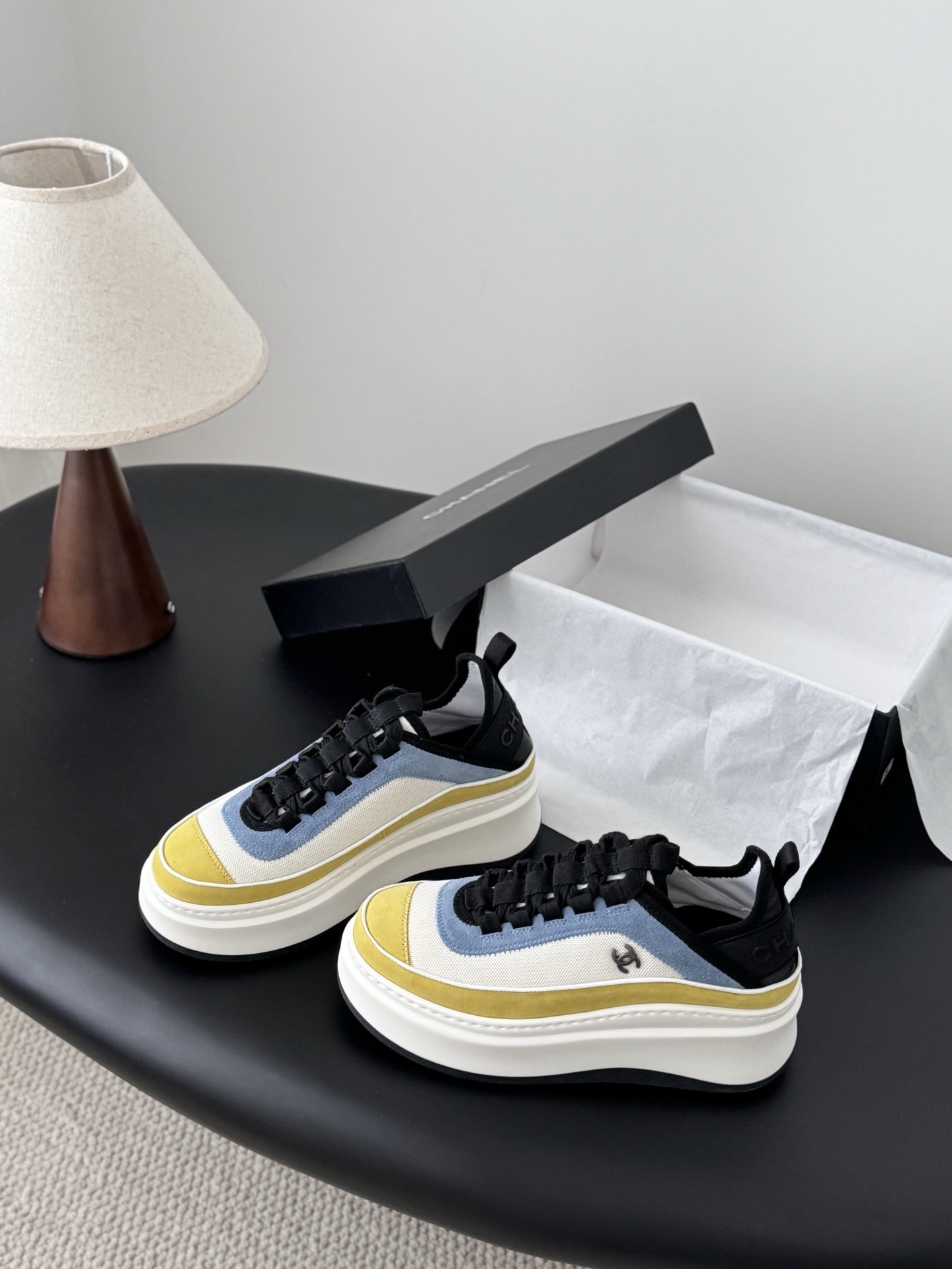 Pair of Chanel multi-color platform sneakers in yellow, blue, and white with black laces and CC logo next to original box - Hình 2