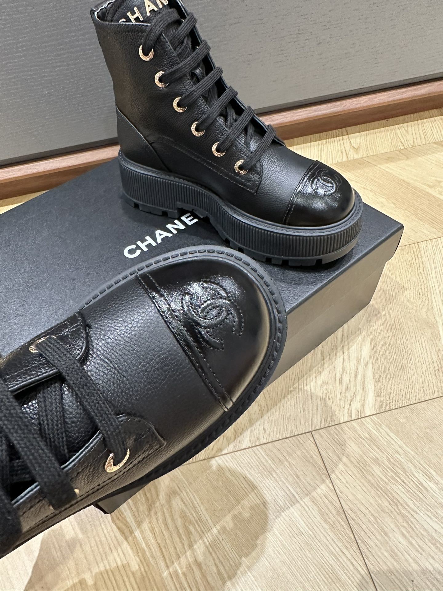 Chanel black leather lace-up combat boots with gold lettering on the tongue and CC logo on the patent toe cap - Hình 5