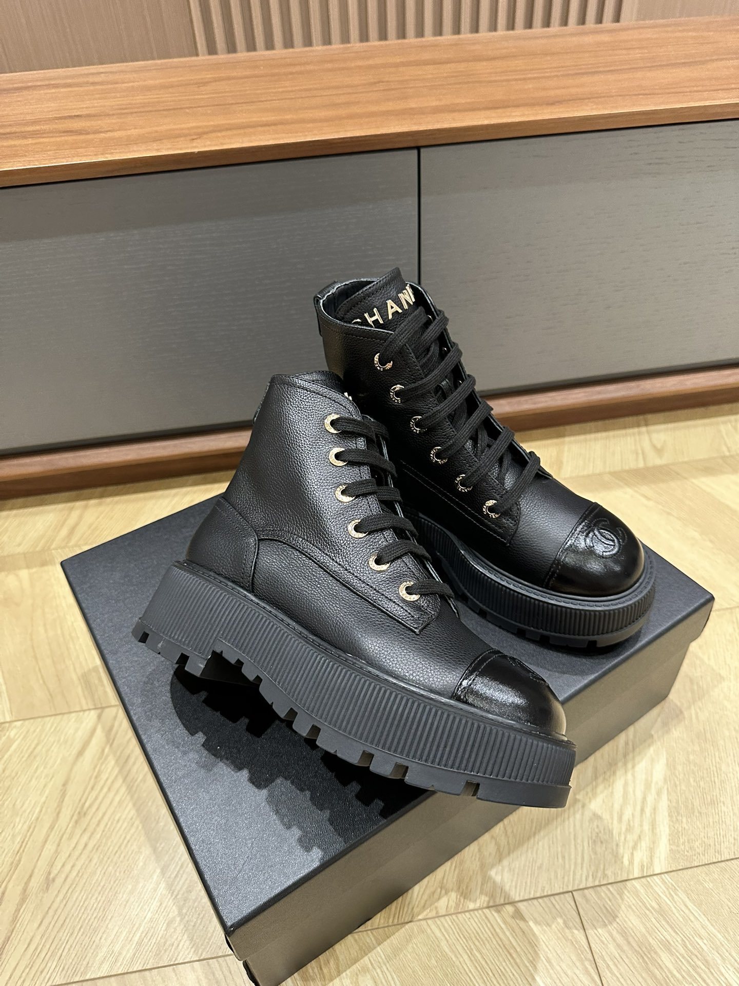 Chanel black leather lace-up combat boots with gold lettering on the tongue and CC logo on the patent toe cap - Hình 4