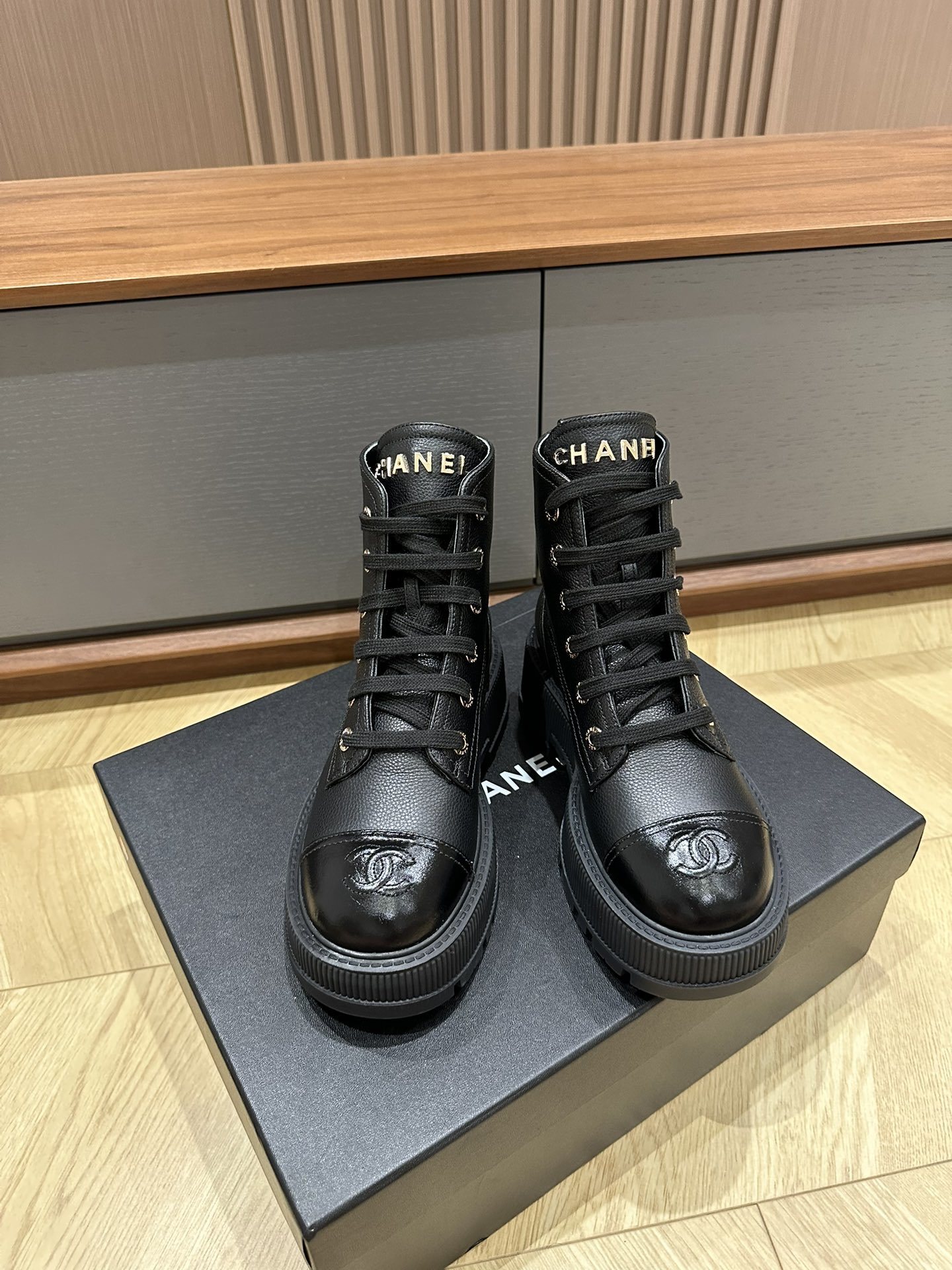 Chanel black leather lace-up combat boots with gold lettering on the tongue and CC logo on the patent toe cap - Hình 2