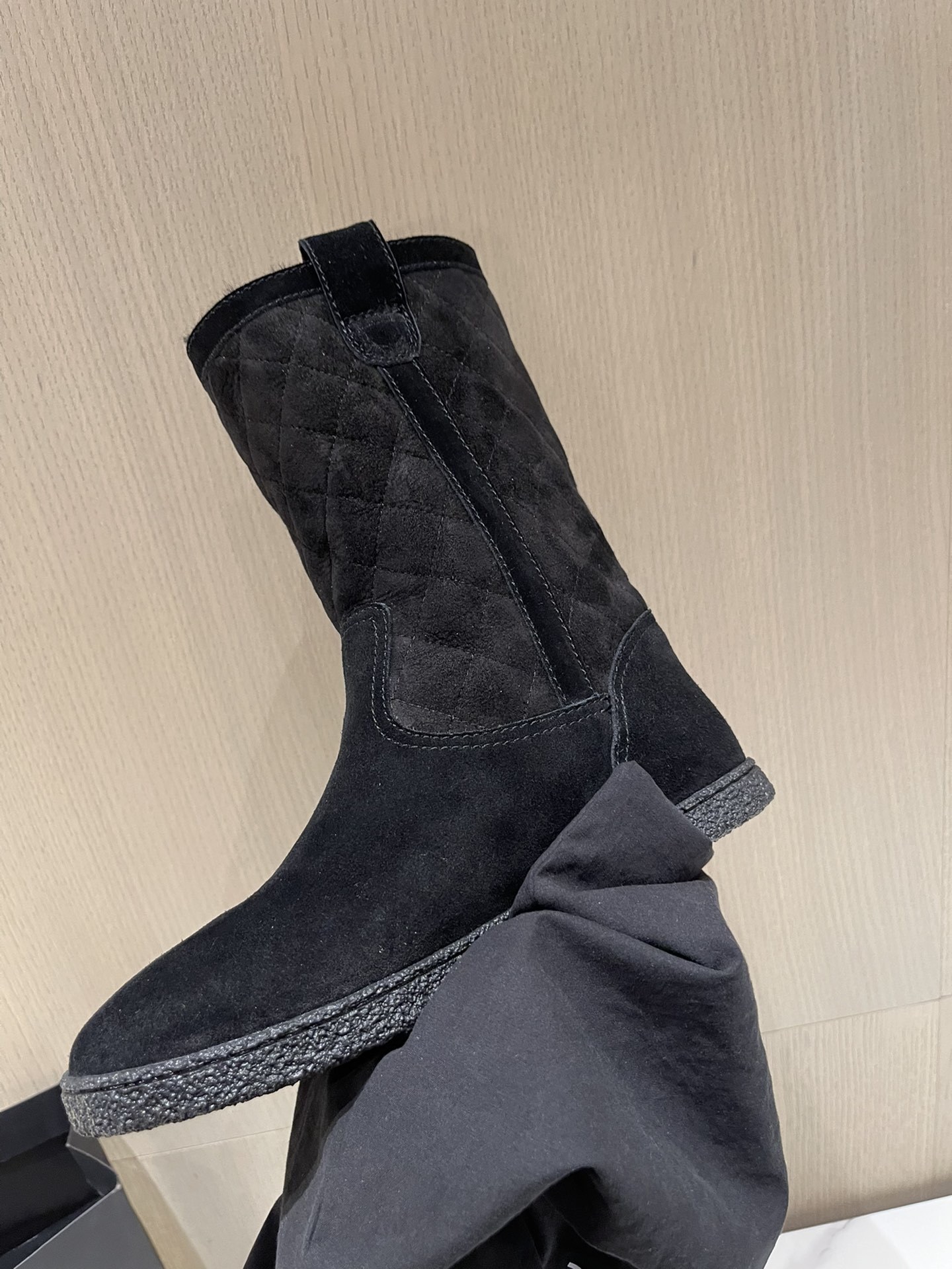 Pair of Chanel black quilted suede mid-calf winter boots with fur lining and gold CC logo displayed on a marble surface. - Hình 7