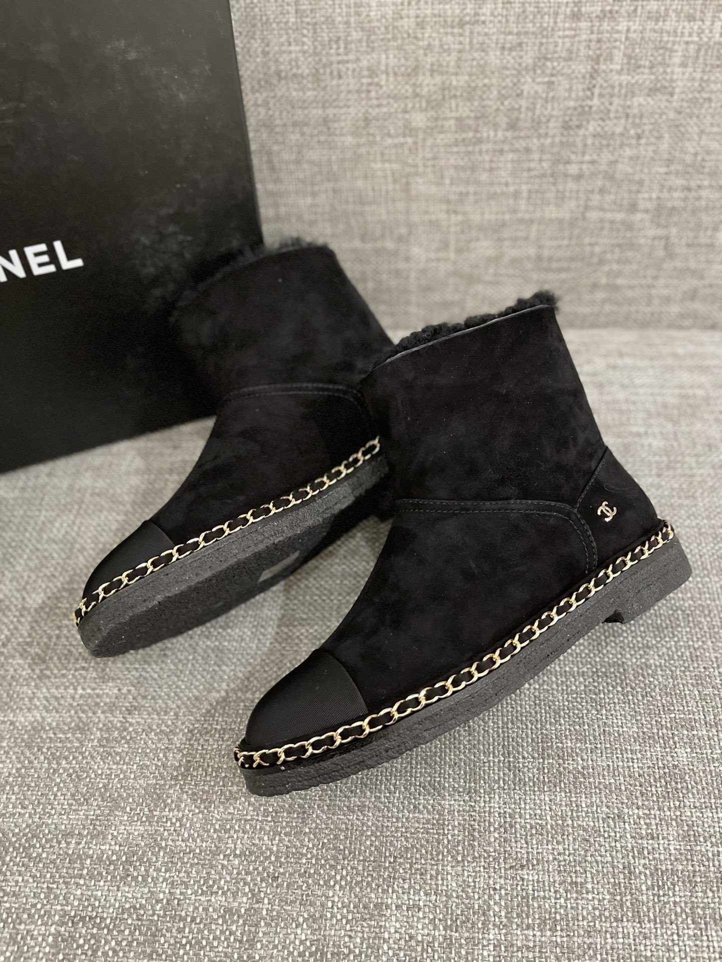 Pair of black Chanel suede ankle boots with shearling lining and gold chain trim around the sole - Hình 9