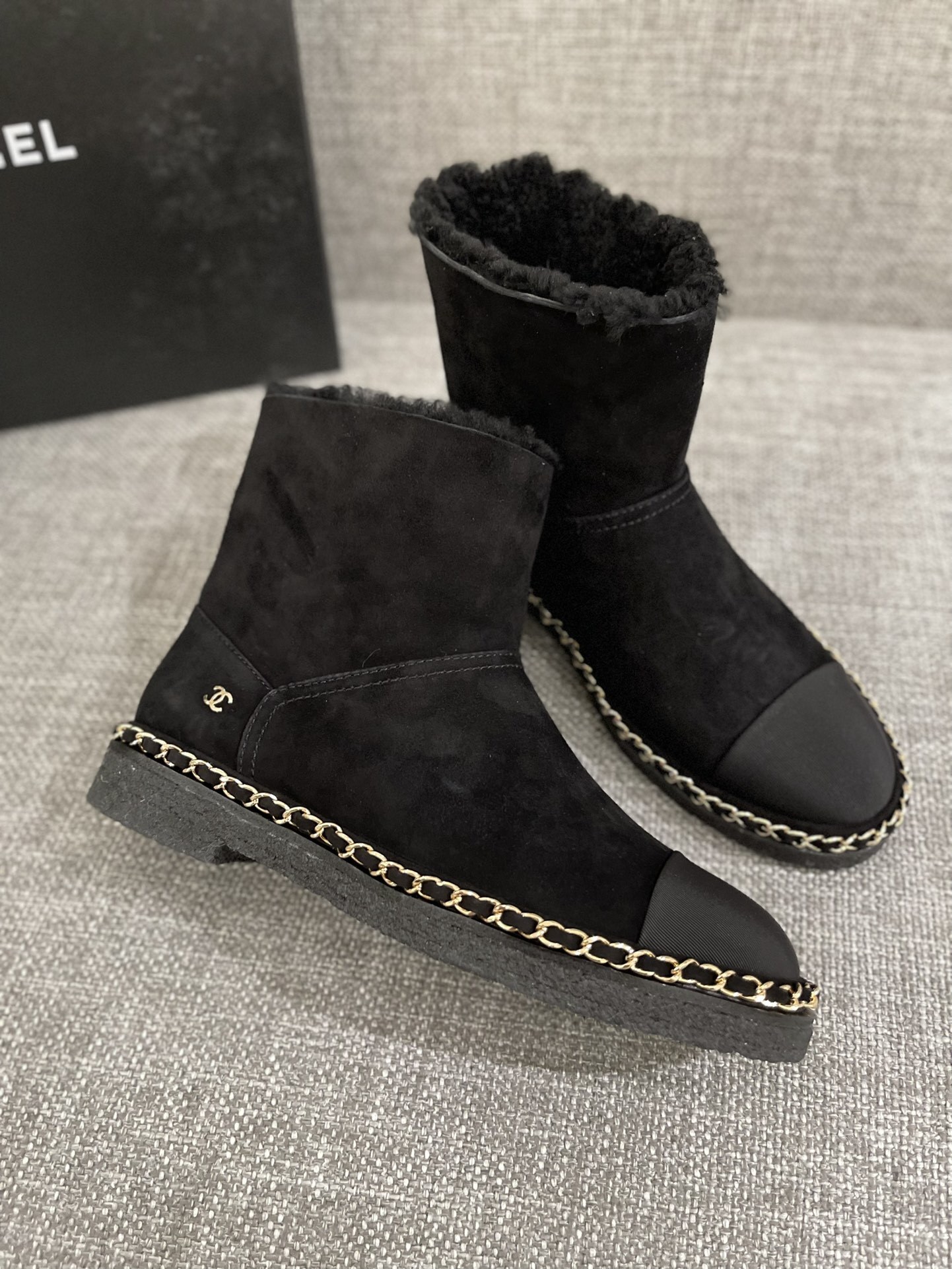 Pair of black Chanel suede ankle boots with shearling lining and gold chain trim around the sole - Hình 3