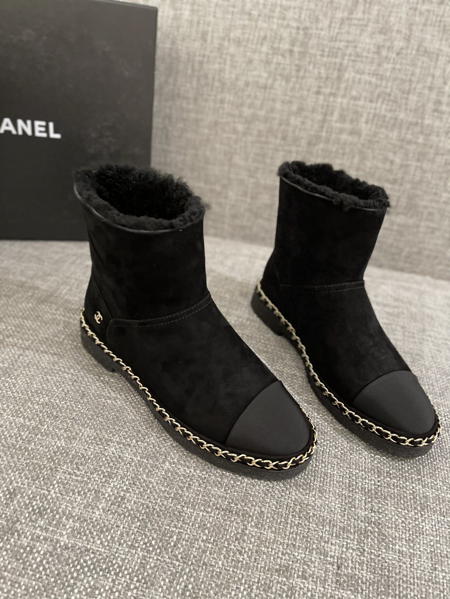 Pair of black Chanel suede ankle boots with shearling lining and gold chain trim around the sole - Hình 2